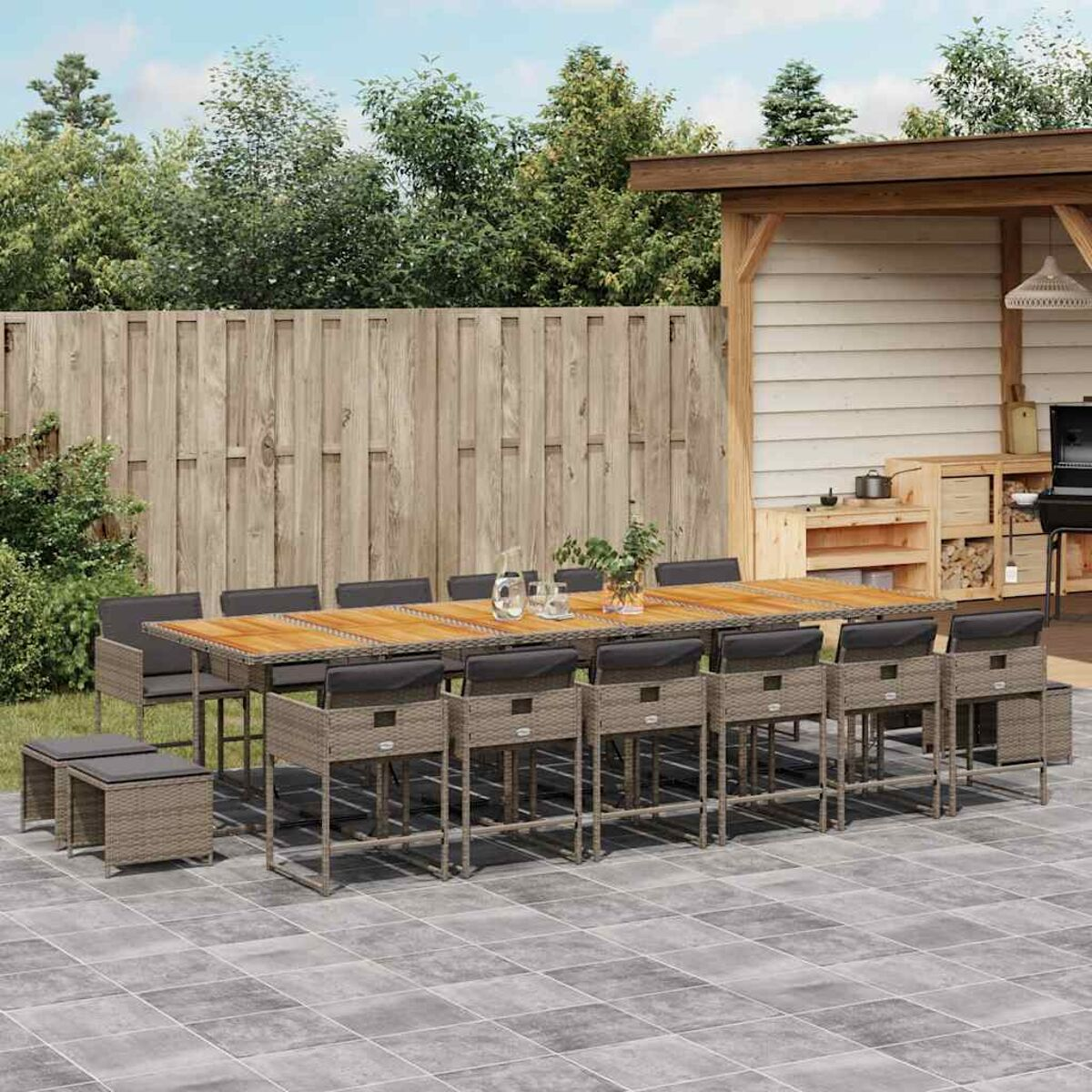 Mesa de comedor exterior larga con sillas y taburetes. Mesa con tapa de madera, sillas de mimbre.