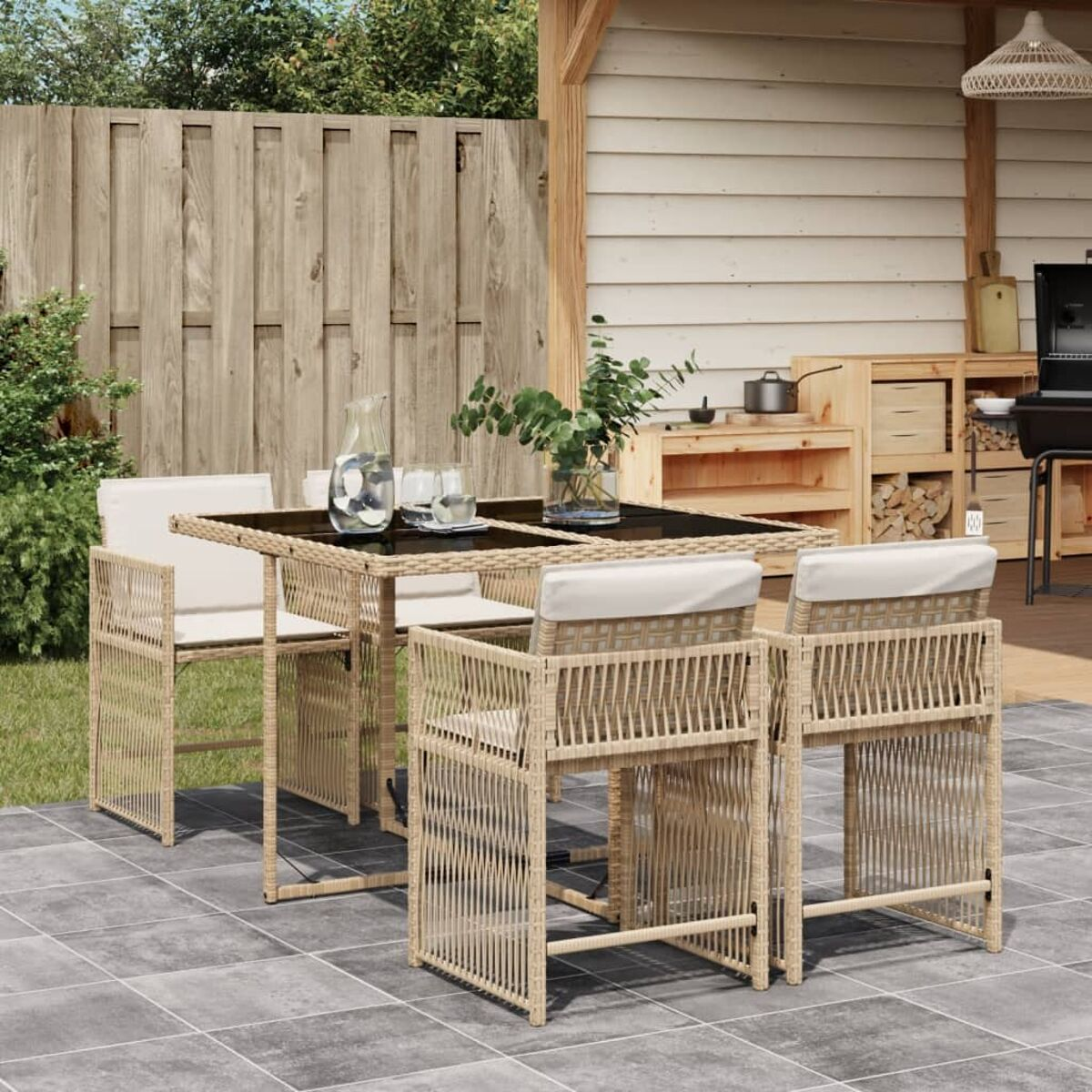 Set da patio con tavolo, sedie e accessori. Include brocca e bicchieri sull' tavolo.