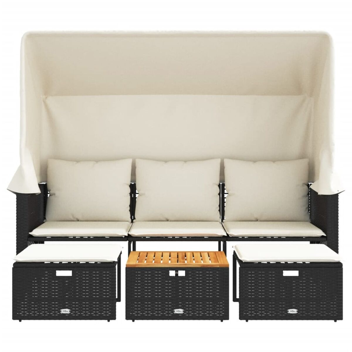 Un divano in rattan nero con baldacchino, tre cuscini e due pouf con un tavolo in legno.