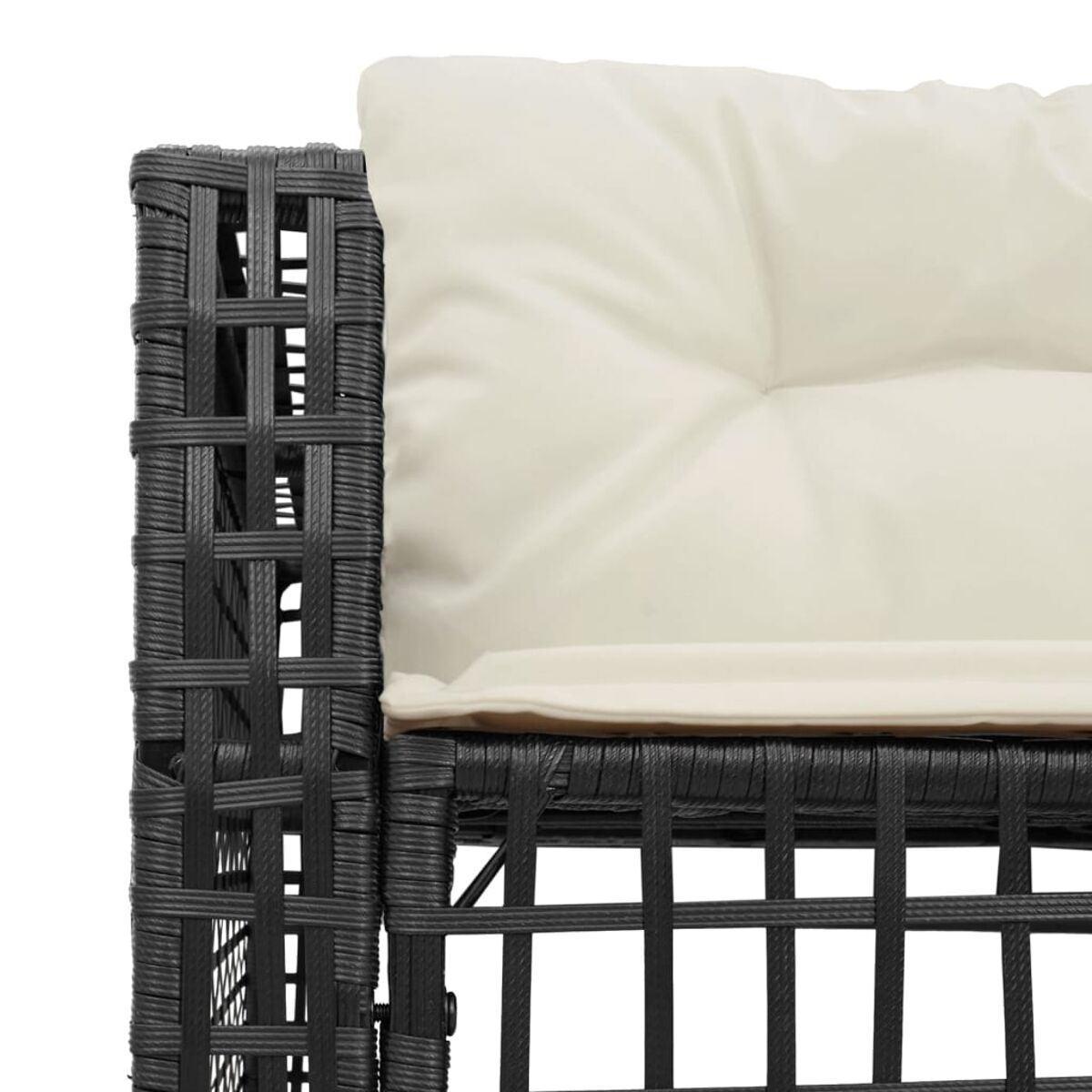 Un primo piano di una sedia in rattan nero, con un cuscino color crema.