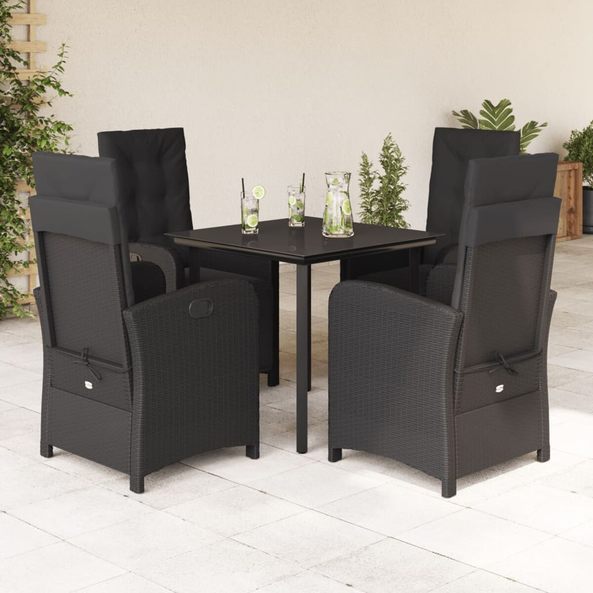Ein Terrassenset mit Tisch, vier Stühlen und Getränken. Eine weiße Wand und Pflanzen sind im Hintergrund.