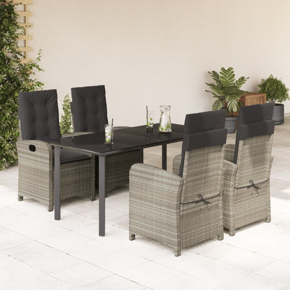 Outdoor-Essgruppe mit grauem Tisch und vier Stühlen mit grauen Kissen. Getränke auf dem Tisch.