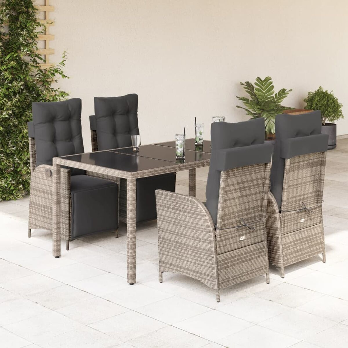 Beiges Korbmöbel-Ess-Set mit Tisch und Stühlen auf einer Terrasse.