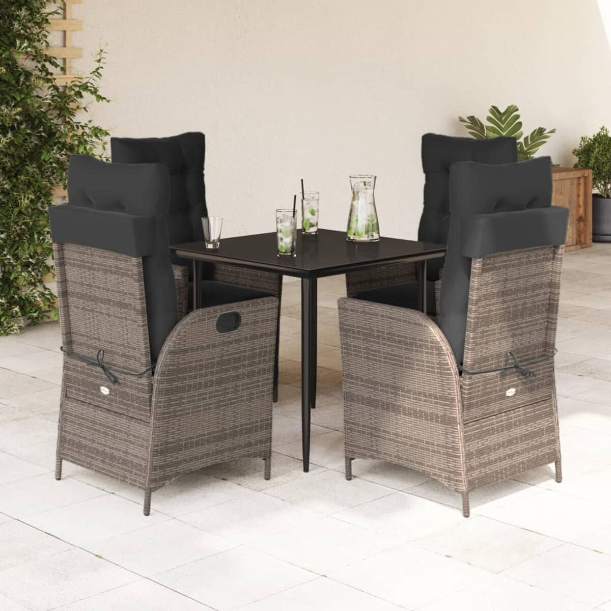Outdoor-Essgruppe mit vier Stühlen, einem Tisch und Dekorationen auf einer Terrasse.