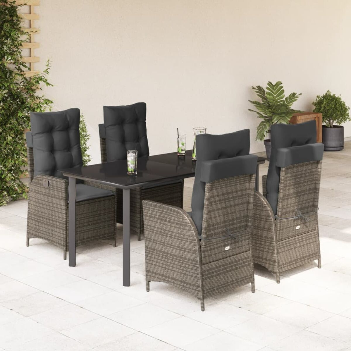 Essgarnitur für den Außenbereich auf einer Terrasse. Enthält einen schwarzen Tisch, vier graue Korbstühle mit schwarzen Kissen.