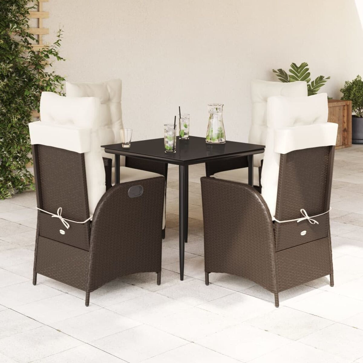 Set da pranzo all'aperto: sedie marroni con cuscini bianchi, tavolo nero, bevande, sul patio.