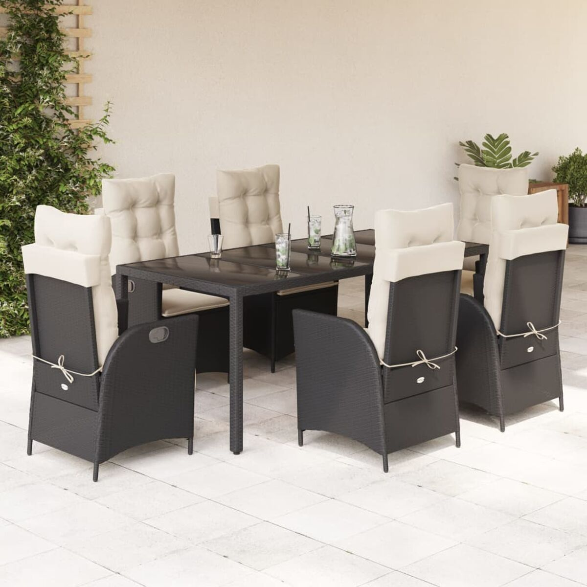 Schwarzer Korbtisch und Stühle. Beige Kissen, neutrale Töne, Garteneinstellung.