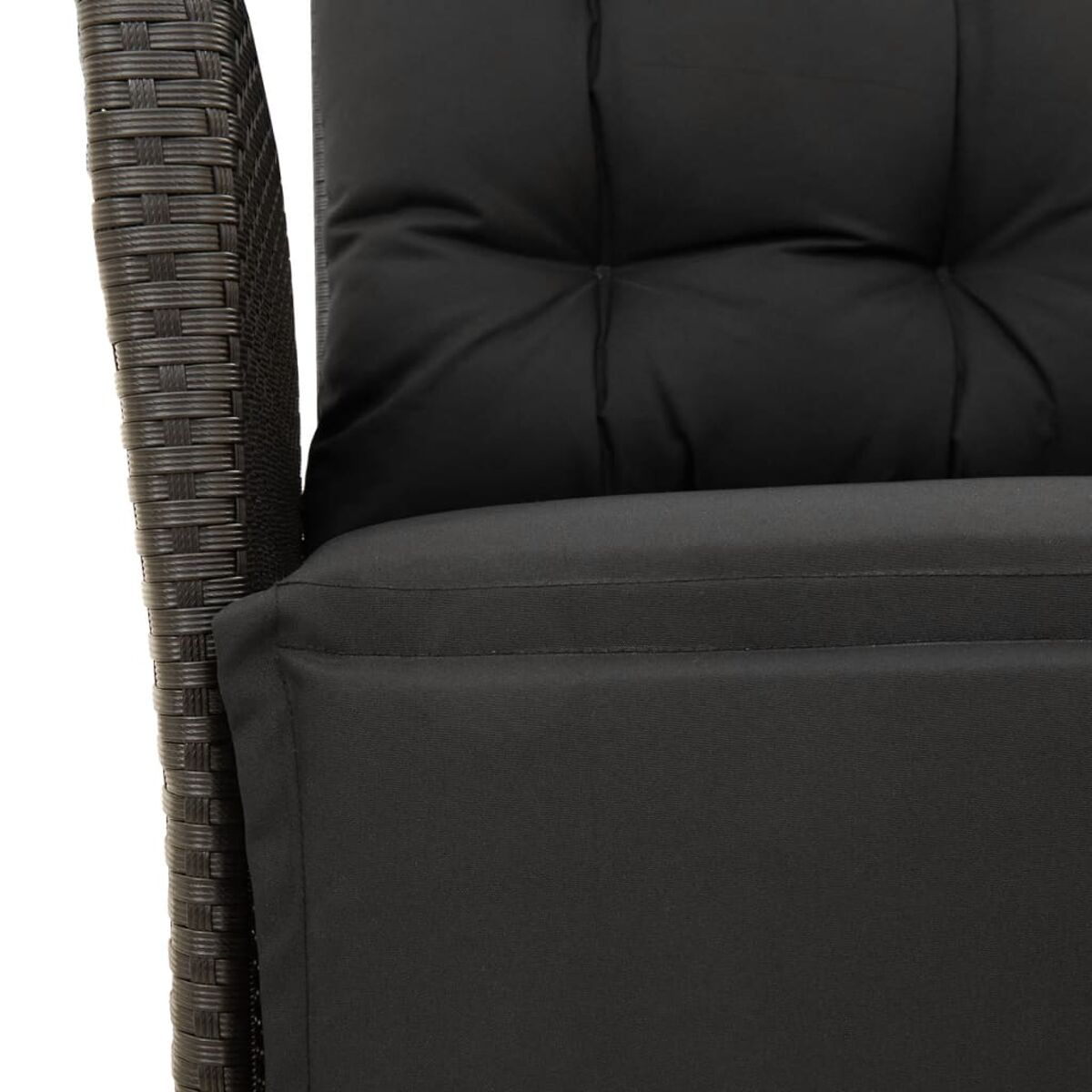 Primo piano di un cuscino nero su una sedia in vimini marrone.