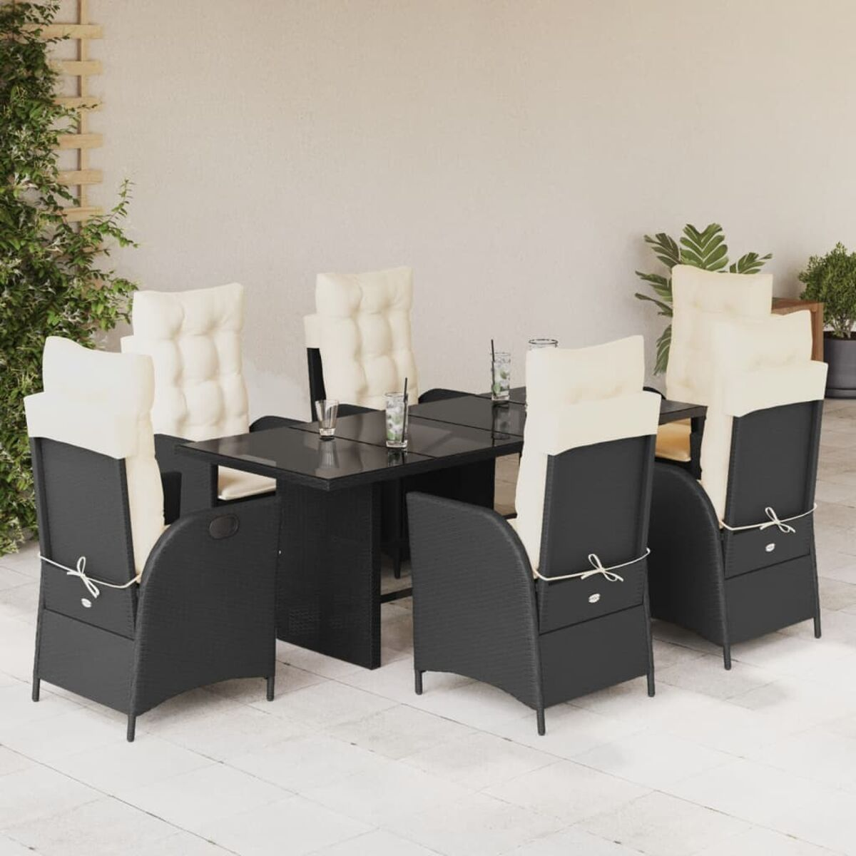 Essgruppe im Freien mit schwarzen Stühlen, Tisch und Getränken auf der Terrasse, cremefarbene Kissen.