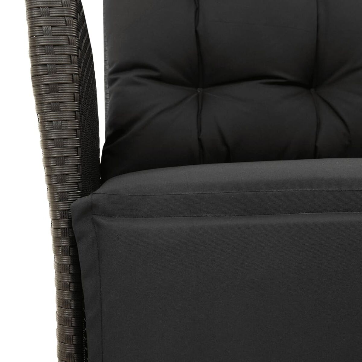 Primo piano di un cuscino nero sullo schienale di una sedia in vimini.