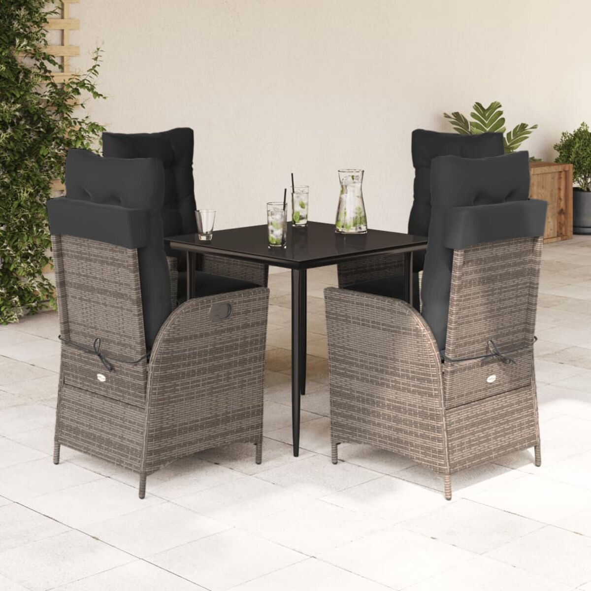Set da patio esterno con quattro sedie in vimini, tavolo e bevande.