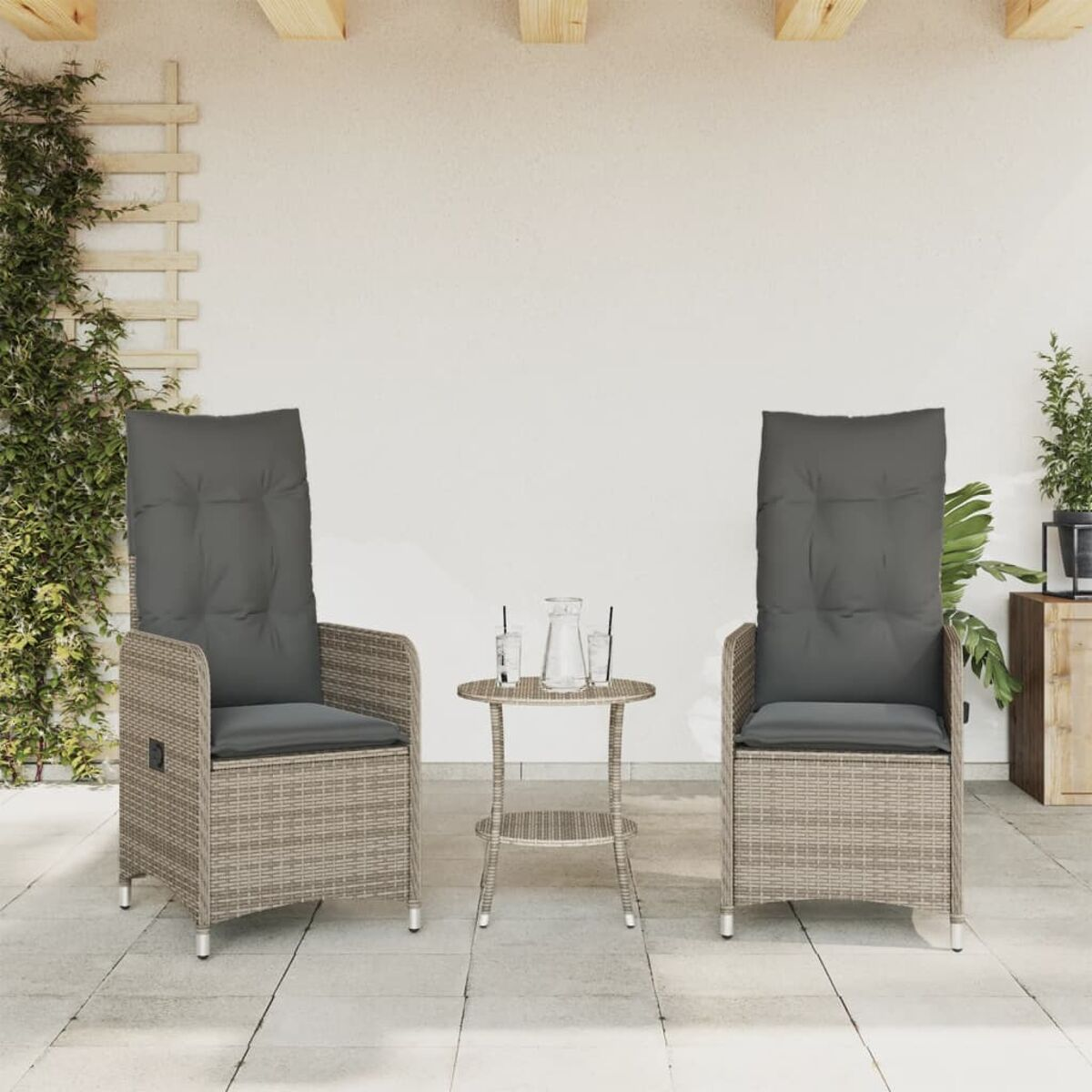 Zwei hochlehnige Korbstühle mit grauen Kissen und einem kleinen Tisch auf einer Terrasse.
