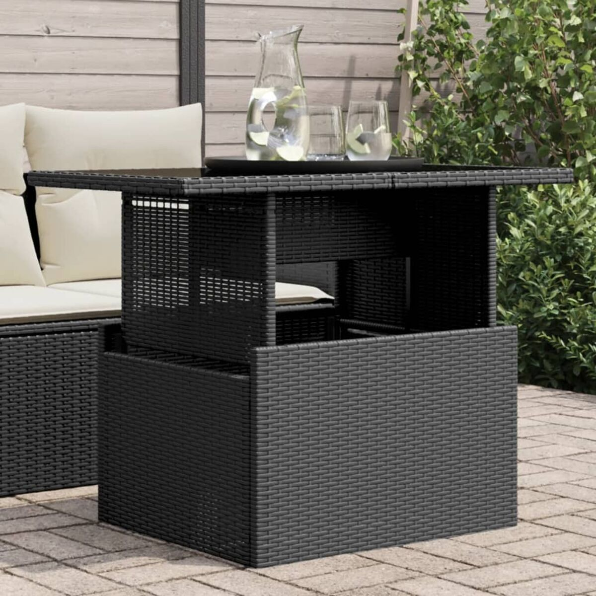 Schwarzer Outdoor-Tisch mit Hebefunktion auf einer Terrasse.