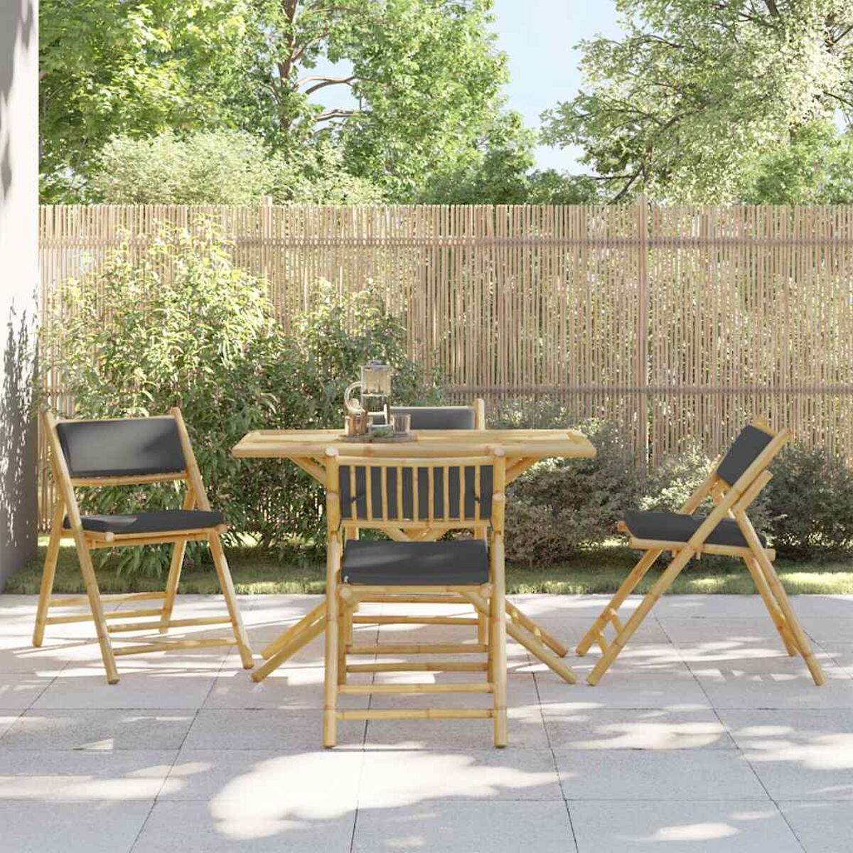 Gartenmöbel-Set mit Tisch und drei Klappstühlen. Grüne Bäume im Hintergrund.