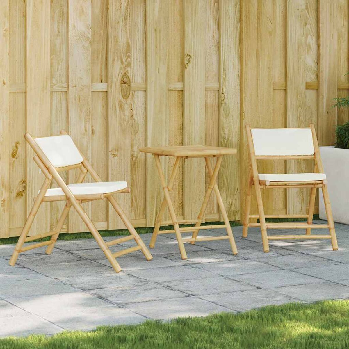 Zwei Klappstühle und ein Tisch auf einer Terrasse.