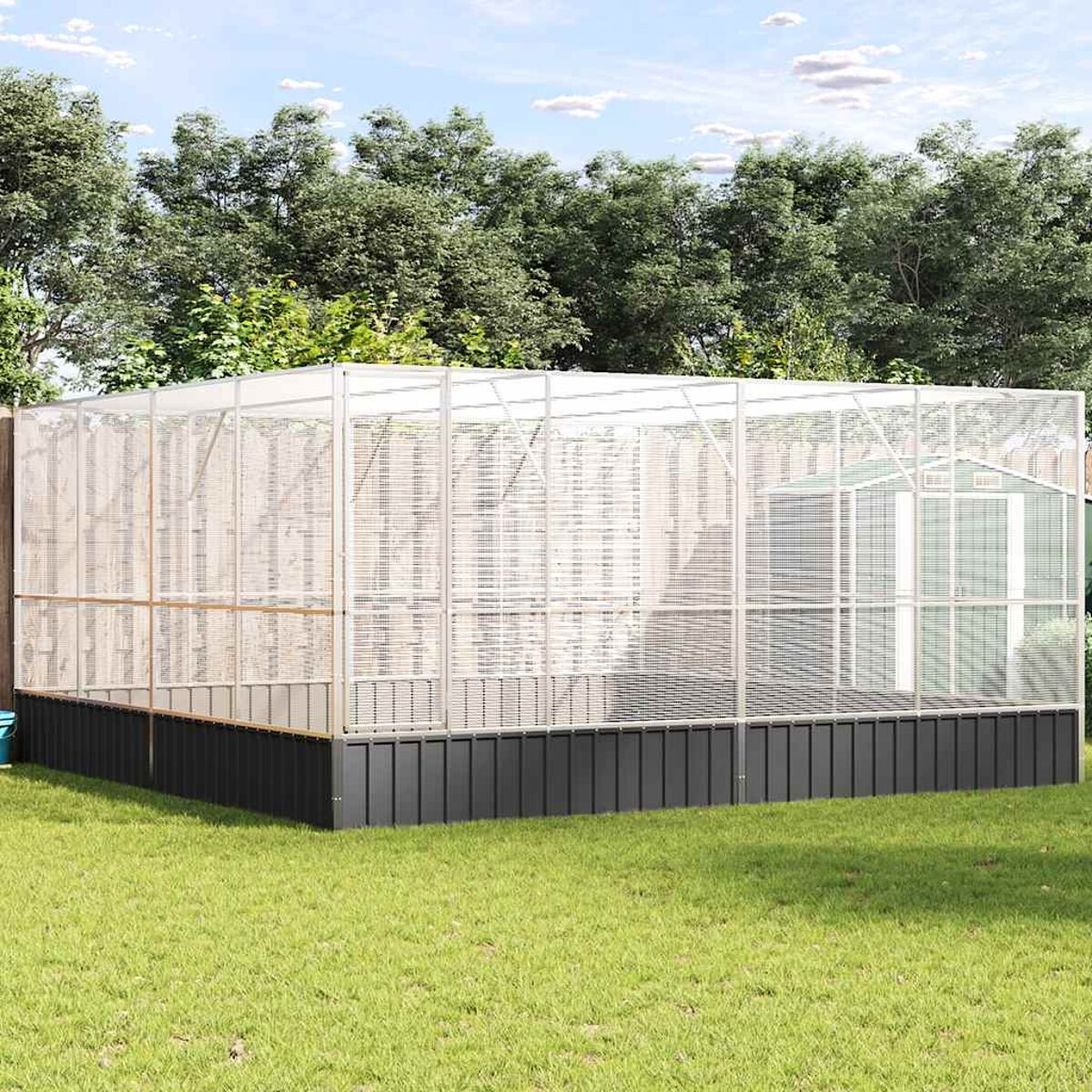 Großes Gewächshaus im Freien mit weißem Rahmen, umgeben von Bäumen auf Gras.