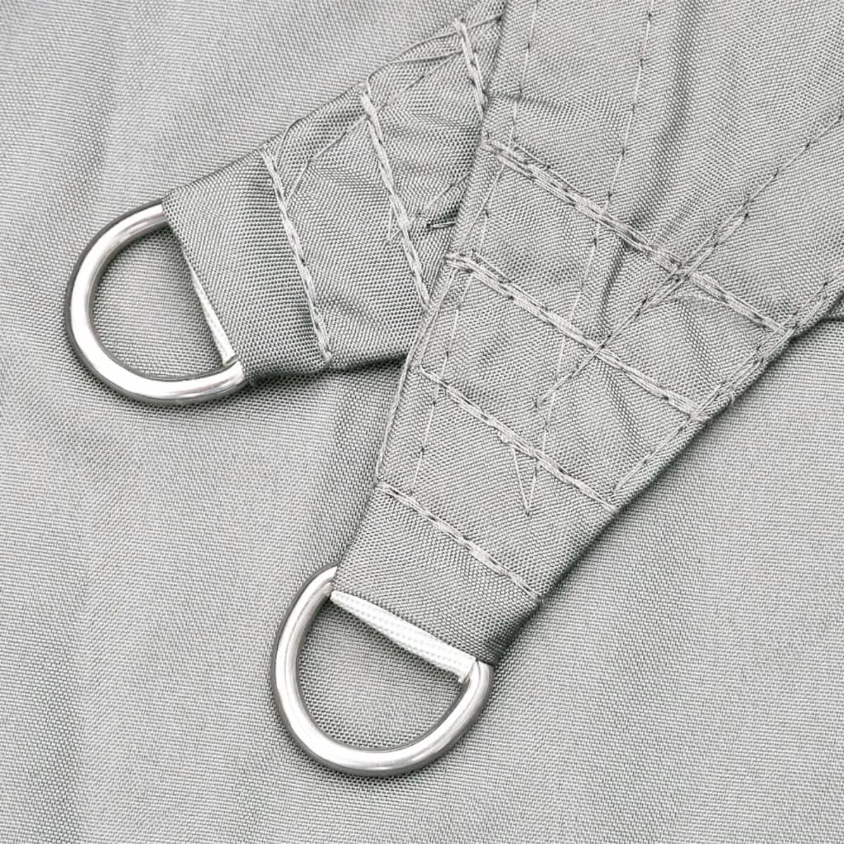 Nahaufnahme von grauem Stoff mit Metall-D-Ringen. Stoff hat genähte Muster. Weißer Hintergrund.