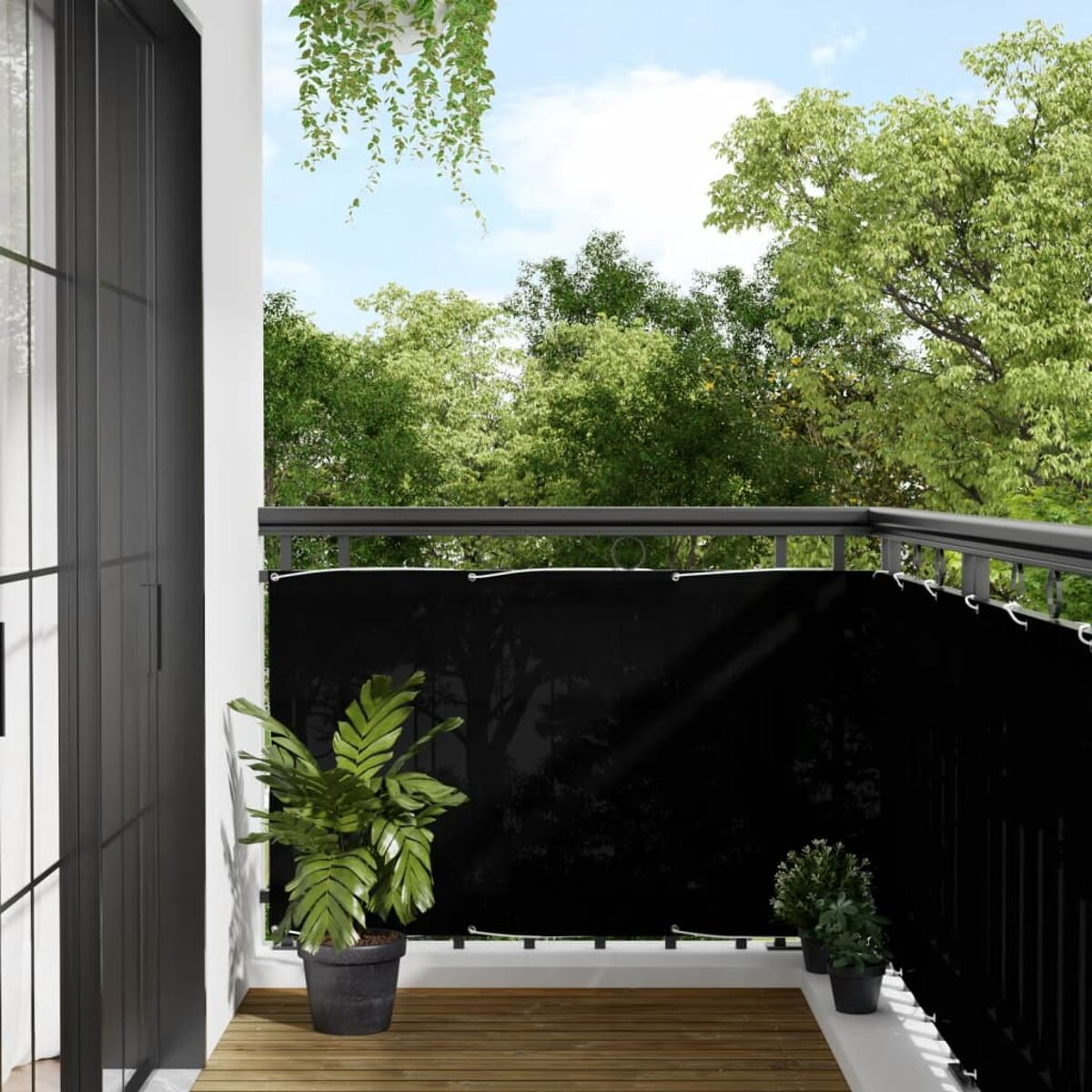 Balkon mit schwarzem Sichtschutz, Pflanzen und Holzboden.