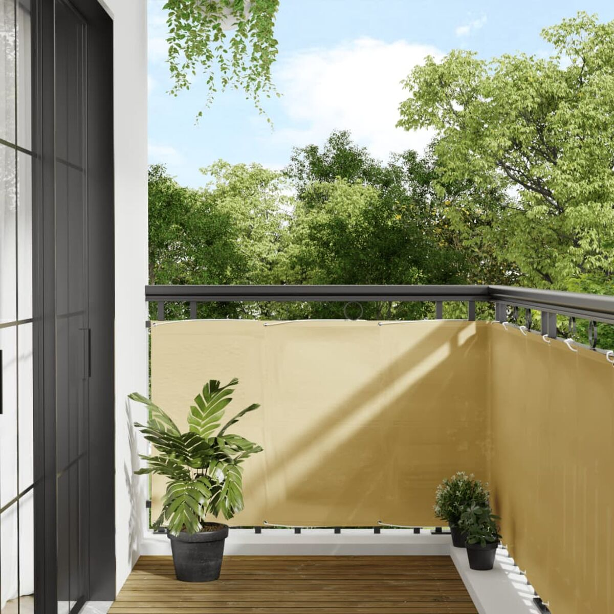 Balkon mit Pflanzen, cremefarbenem Sichtschutz und Bäumen im Hintergrund unter blauem Himmel.