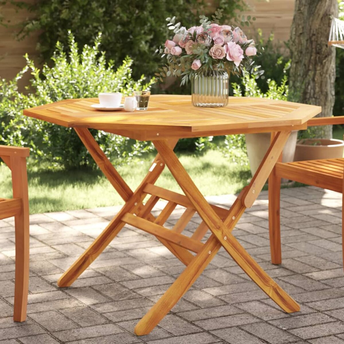 Sechseckiger Holztisch mit Blumen und Tassen, im Freien.