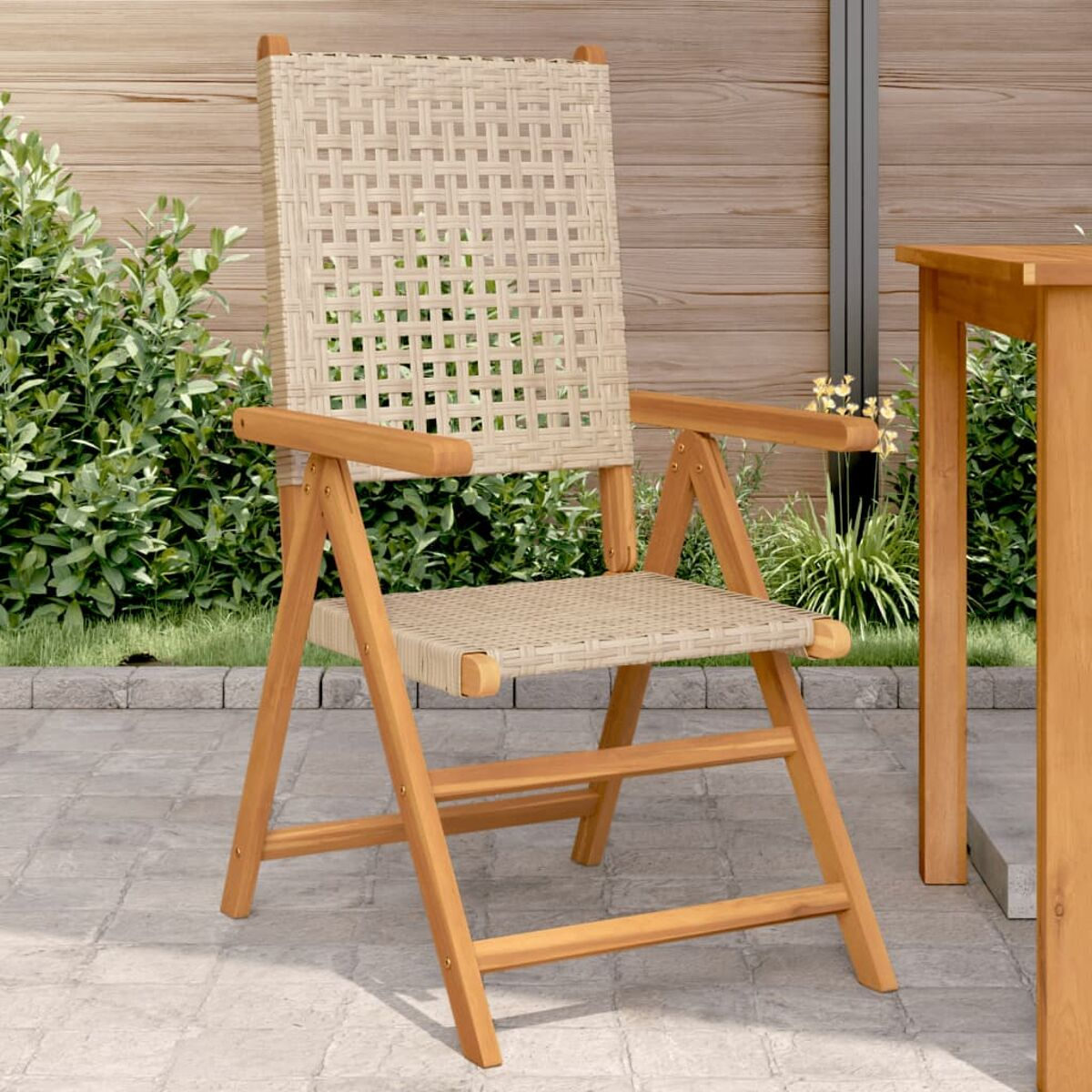 Klappstuhl aus Holz mit gewebtem Sitz und Rücken. Es befindet sich im Freien auf einer Terrasse.