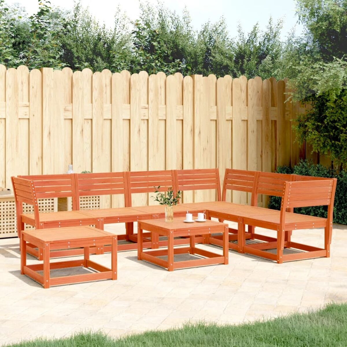 Gartenmöbel-Set in Orange, bestehend aus Sofa, Tischen und einem Zaun im Hintergrund.