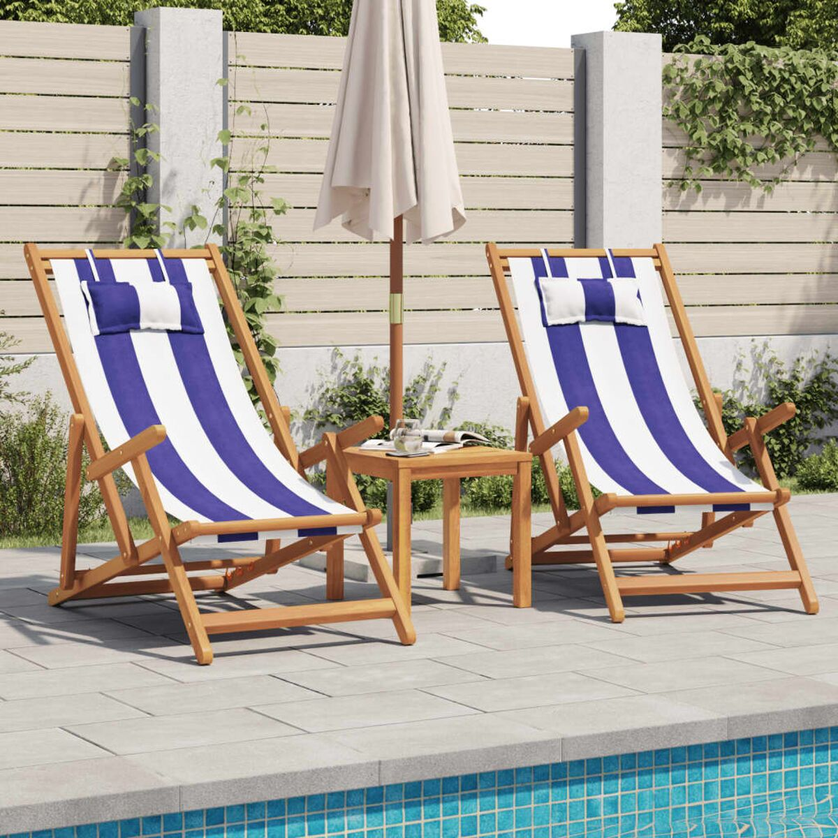 Zwei Strandstühle mit blau-weißen Streifen, kleiner Tisch, Sonnenschirm am Pool.