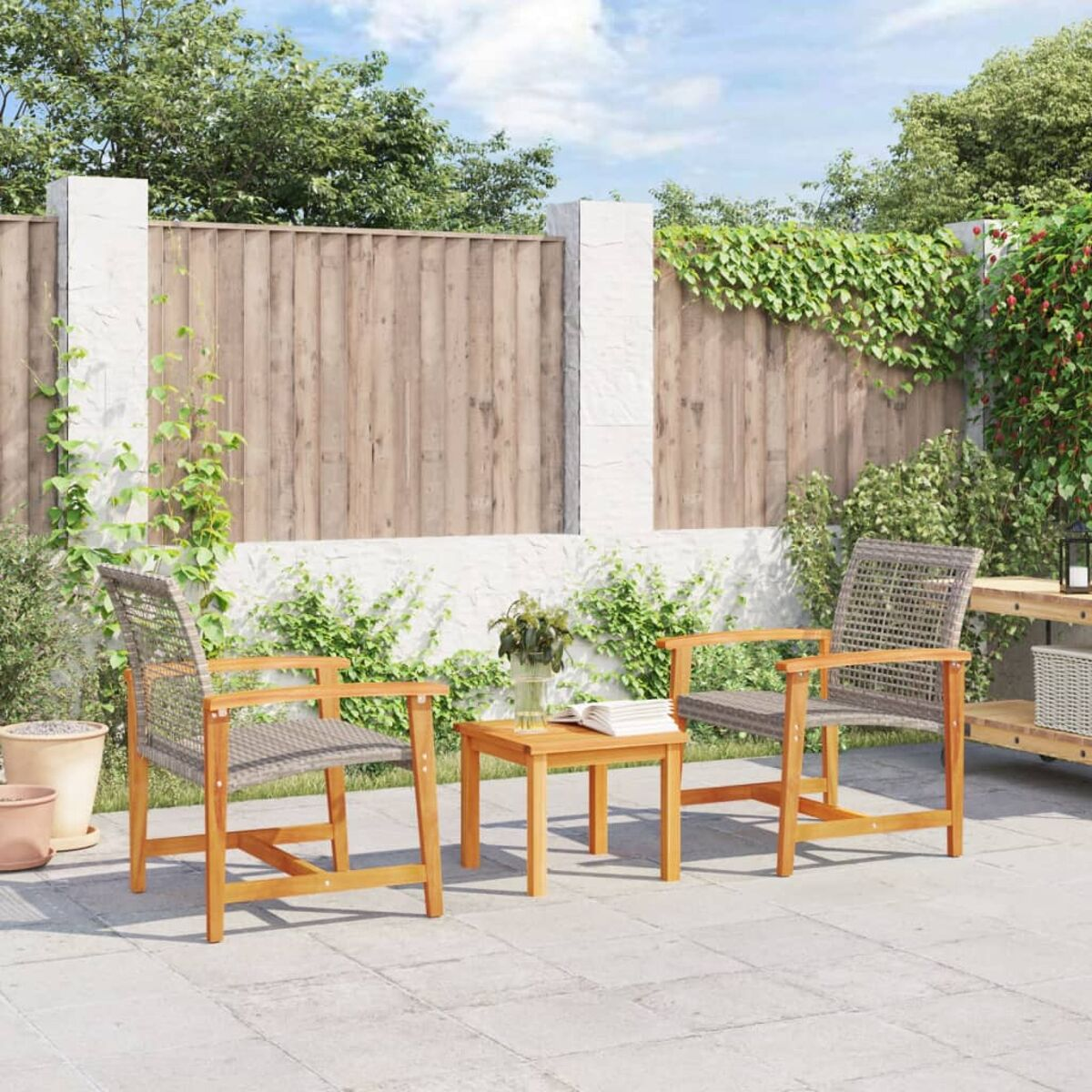 Terrassenset: zwei Stühle, kleiner Tisch, Holzzaun und Grün in einer sonnigen Umgebung.