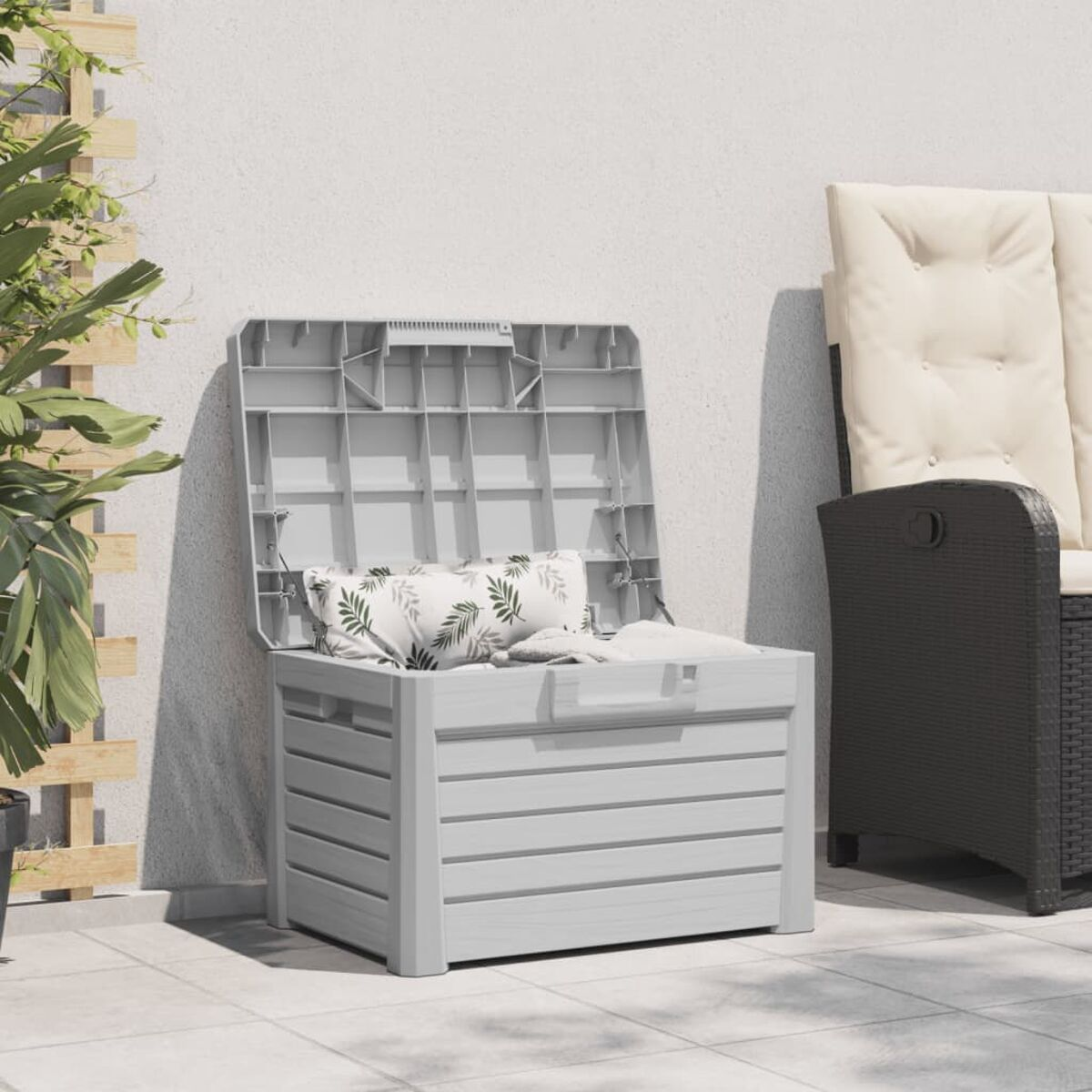 Outdoor-Aufbewahrungsbox, offen, mit Kissen, neben einem Stuhl.