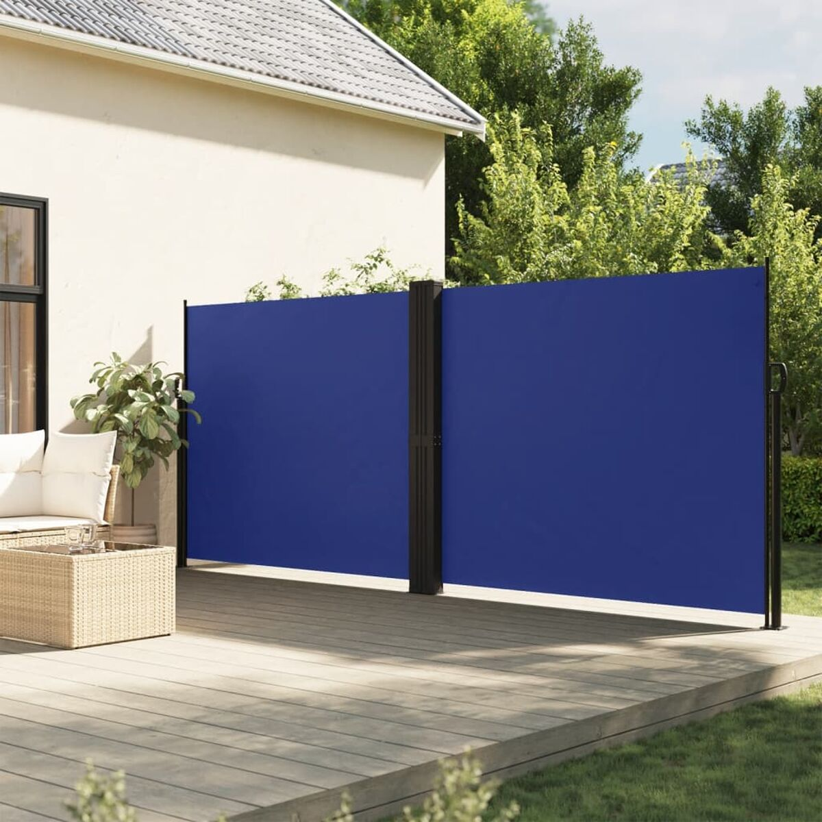 Blaue Leinwand auf einer Holzterrasse im Garten installiert. Weißes Haus und Grün im Hintergrund.