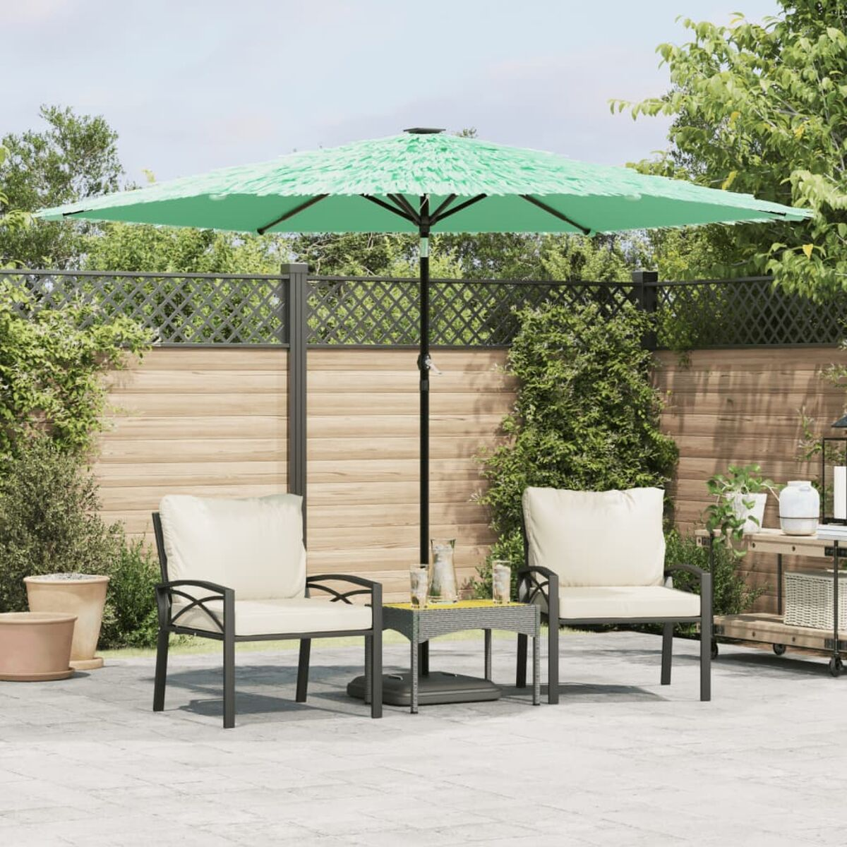 Una scena del patio con un ombrello verde e due sedie con cuscini color crema.