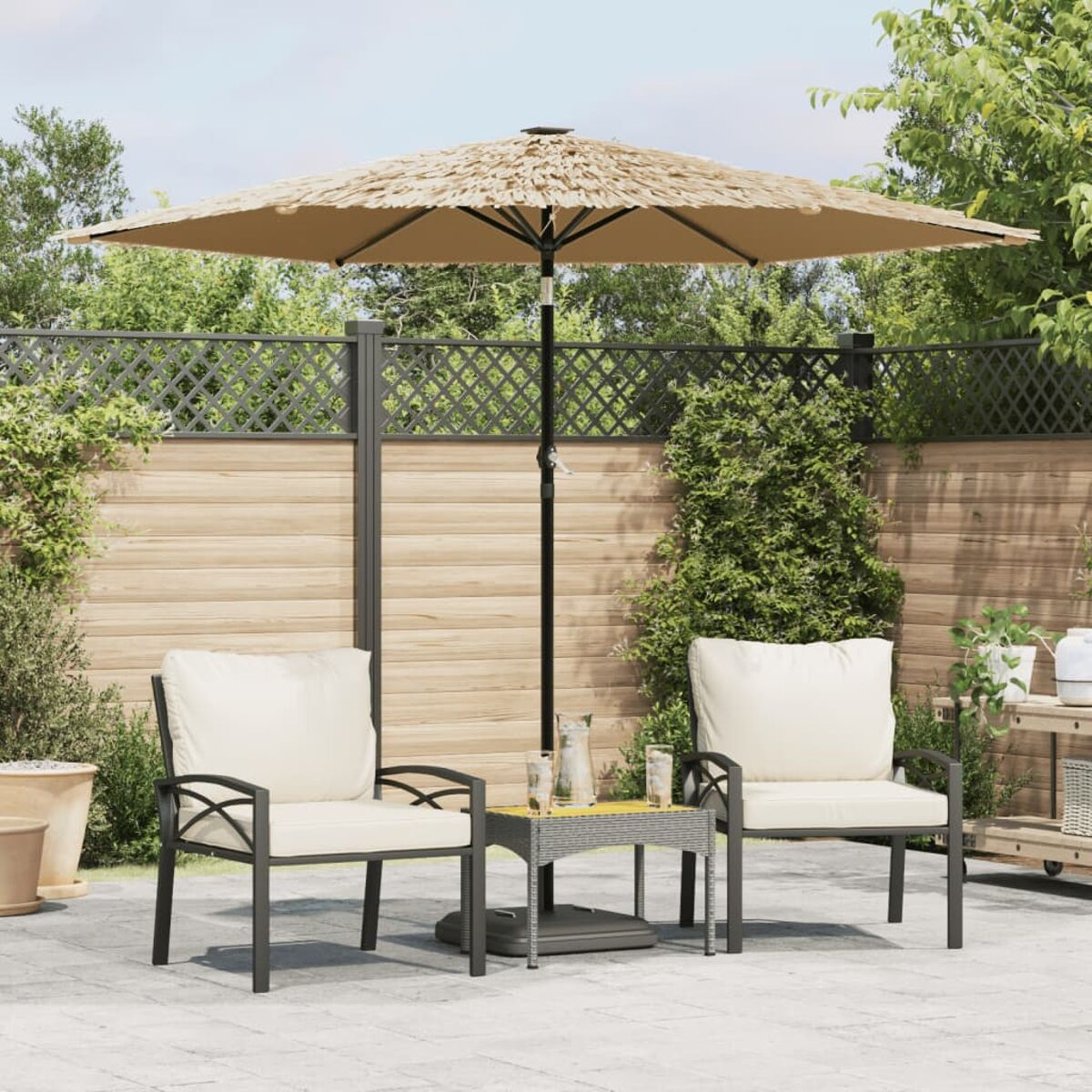 Outdoor-Terrassenset mit Stühlen, Tisch und Sonnenschirm, umgeben von Grün.