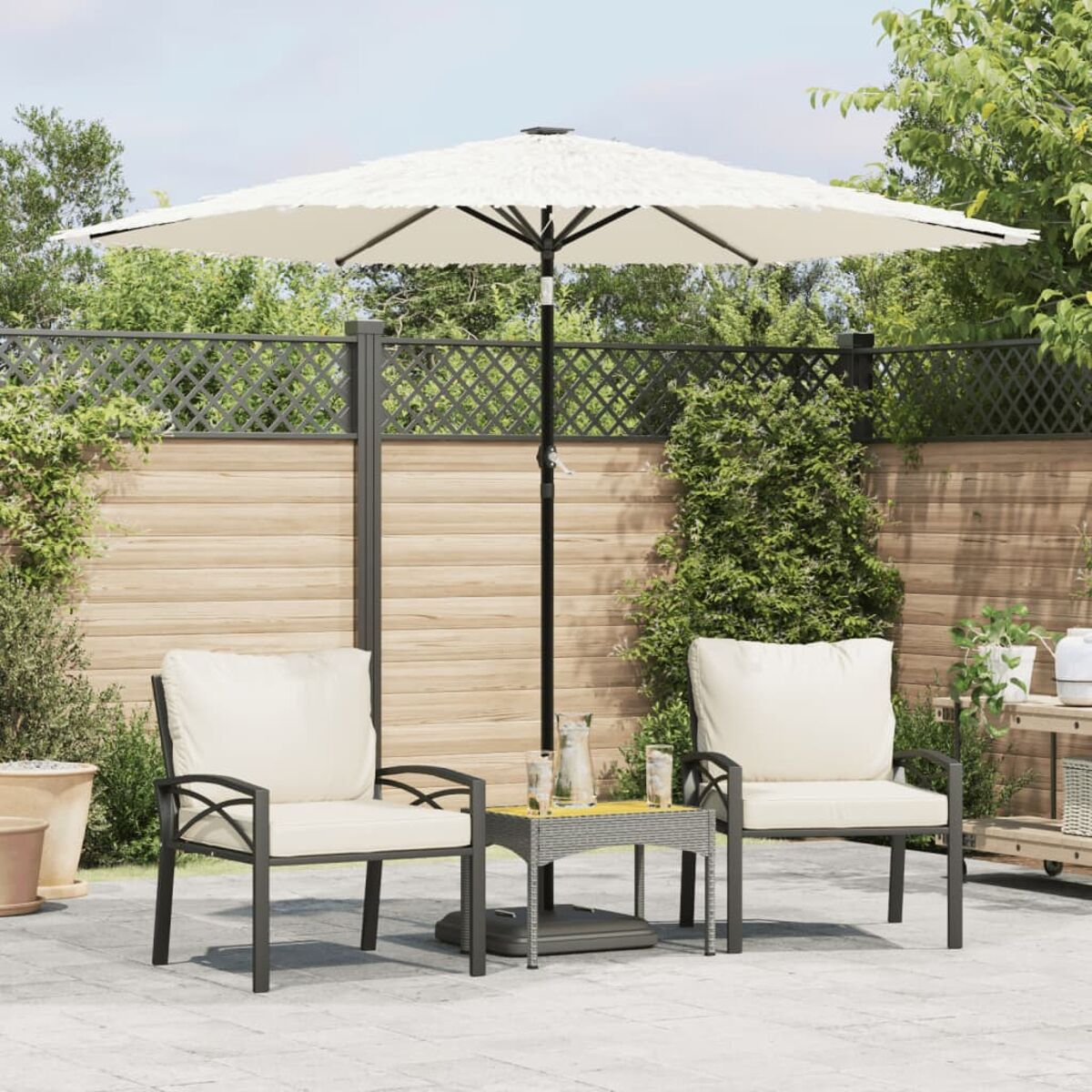 Terrassenset im Freien mit Schirm, zwei Stühlen und Tisch. Im Hintergrund ein Garten.