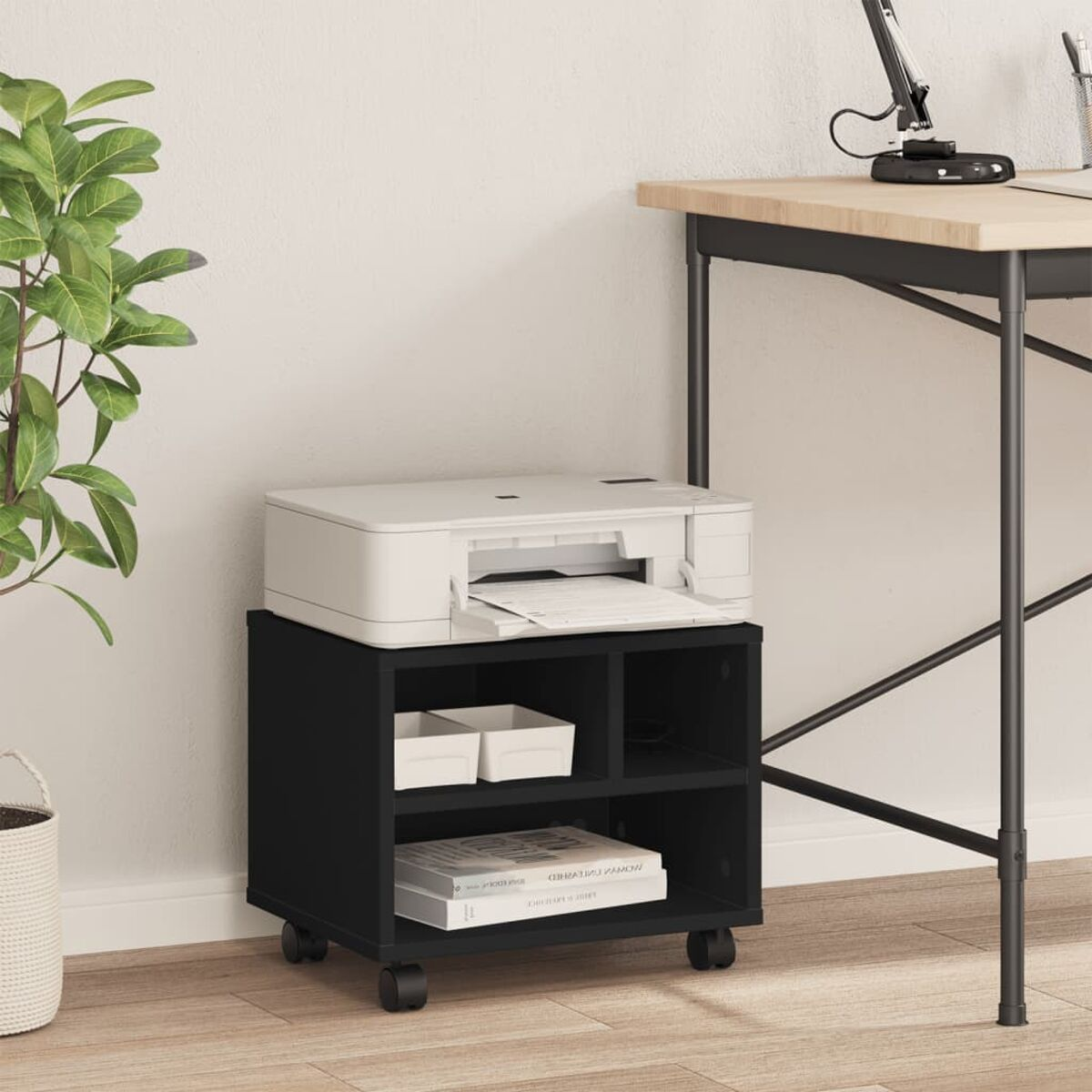 Schwarzer, rollbarer Druckerstand mit Drucker, Ablagen und Büchern. Heller Wandhintergrund.