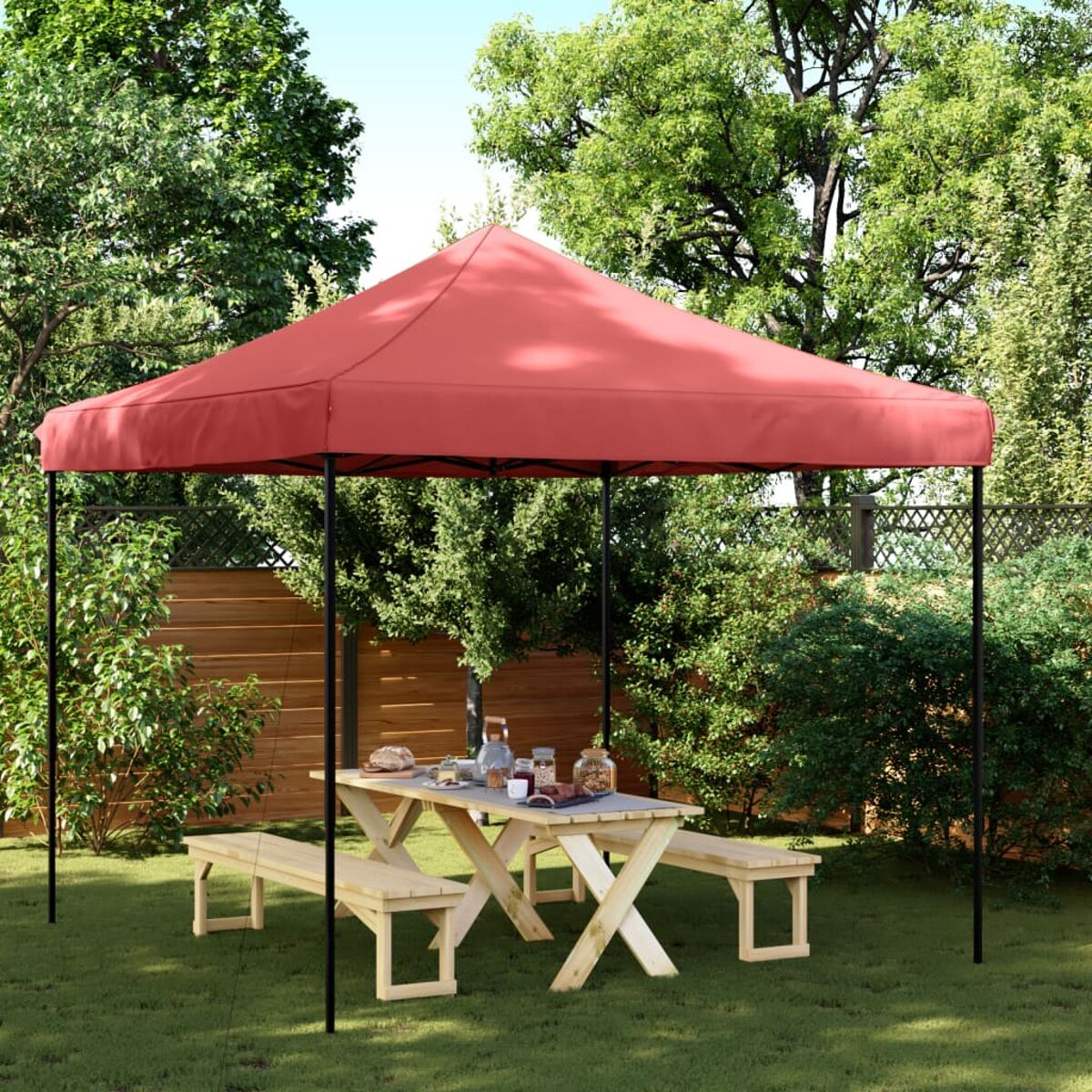 Roter Pavillon mit schwarzem Rahmen im Garten. Picknicktisch und Bänke unter dem Pavillon.