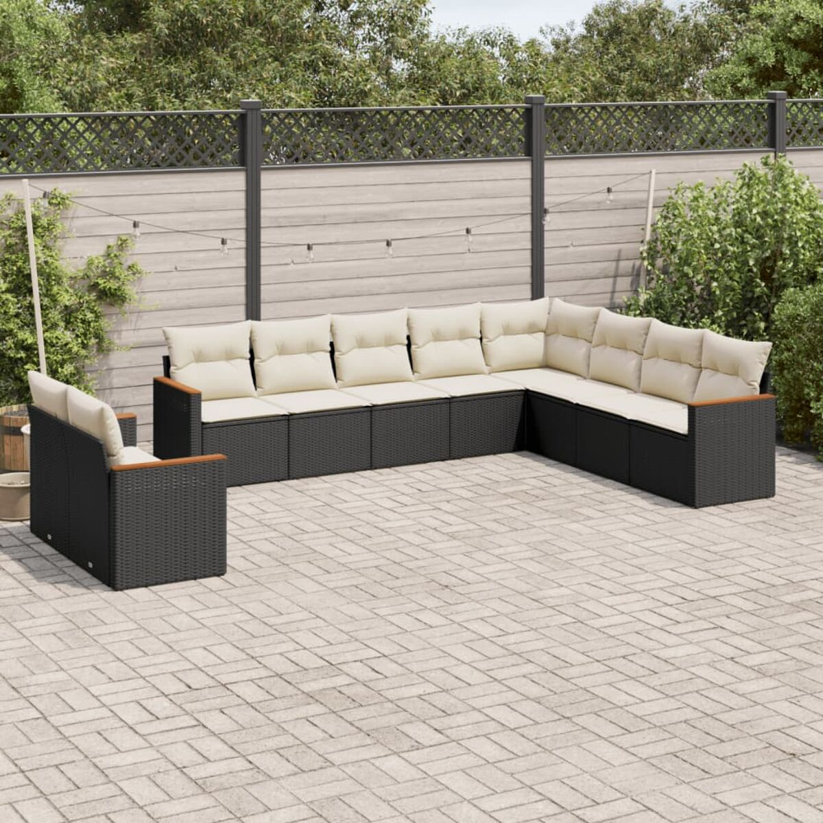 Schwarzes Outdoor-Rattansofa-Set mit beigen Kissen. Das Set umfasst ein Ecksofa und einen Einzelsitz auf einer Terrasse.