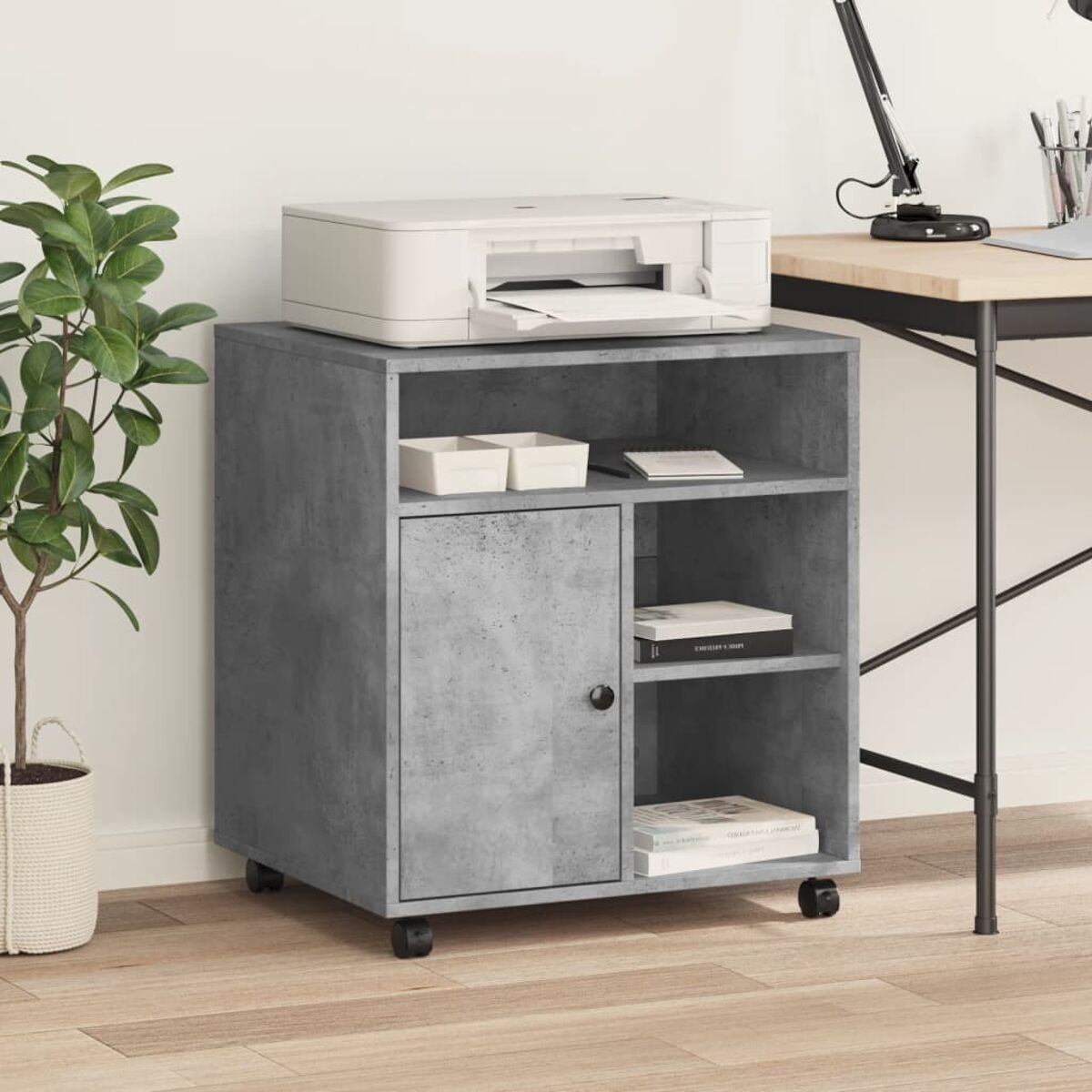 Ein grauer Schrank mit Regalen, einer Tür und einem Drucker oben, neben einer Pflanze.
