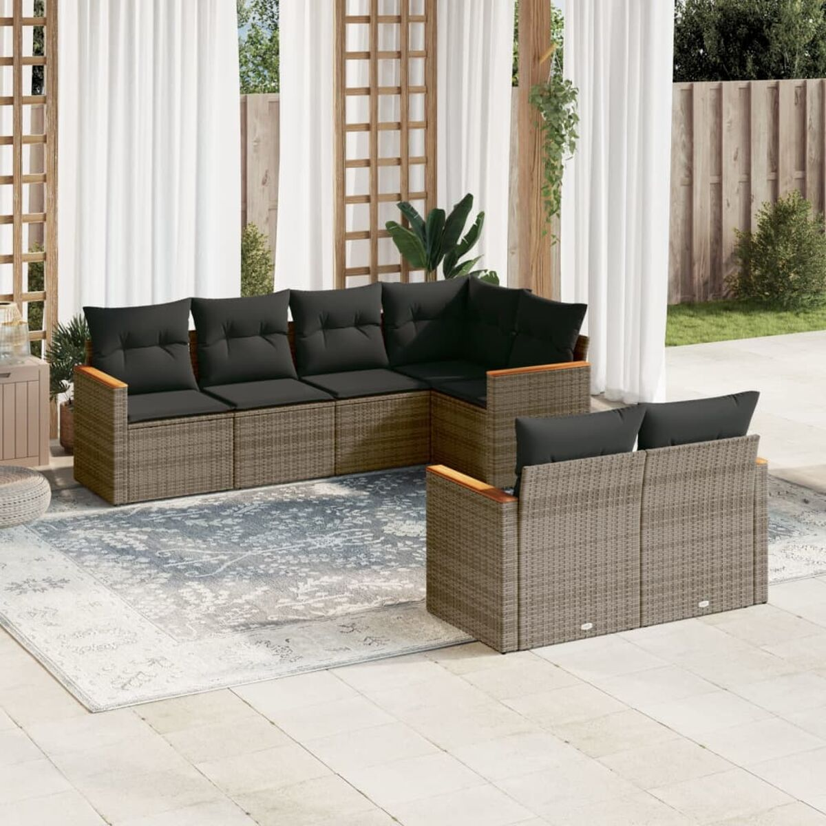 L-förmiges Outdoor-Sofa. Graue Kissen, brauner Rahmen. Auf einer Terrasse platziert.