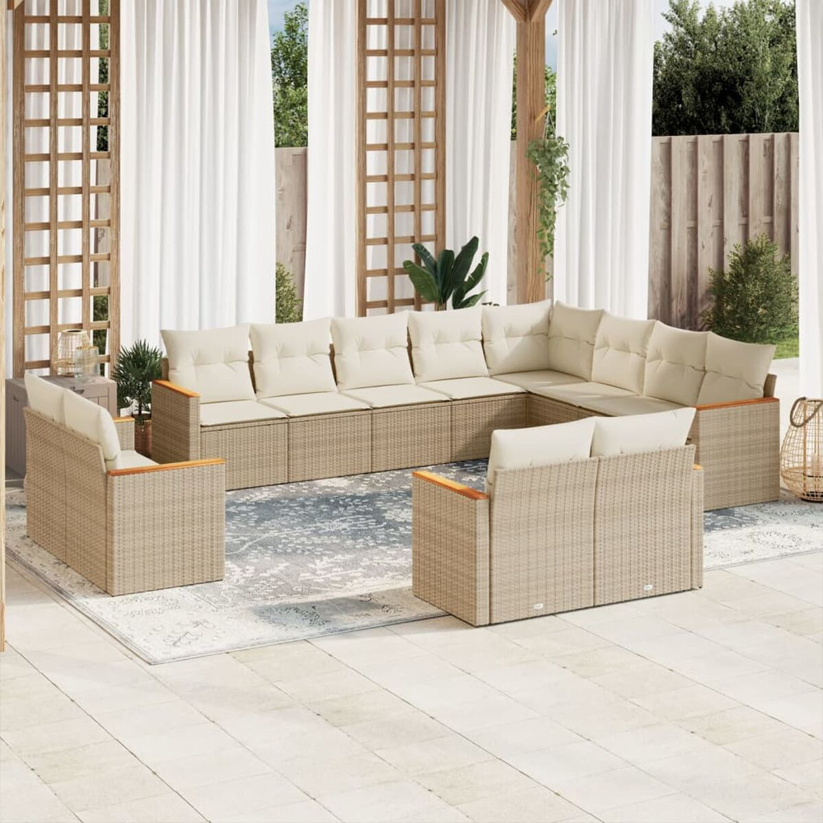 Sitzbereich im Freien mit großem Ecksofa und Sesseln. Beige Kissen.