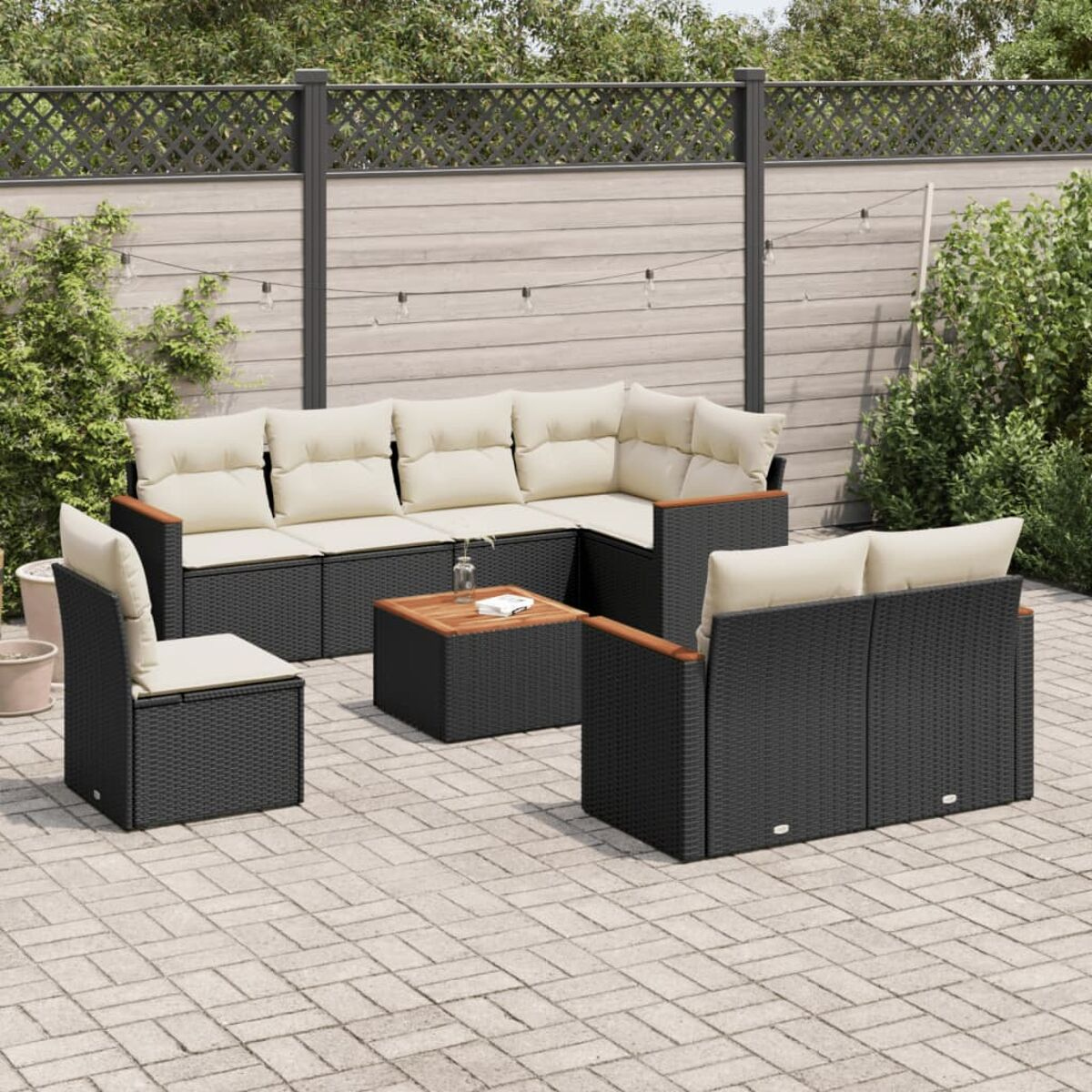 Schwarzes Outdoor-Möbelset aus Korbgeflecht mit cremefarbenen Kissen. Quadratischer Tisch.