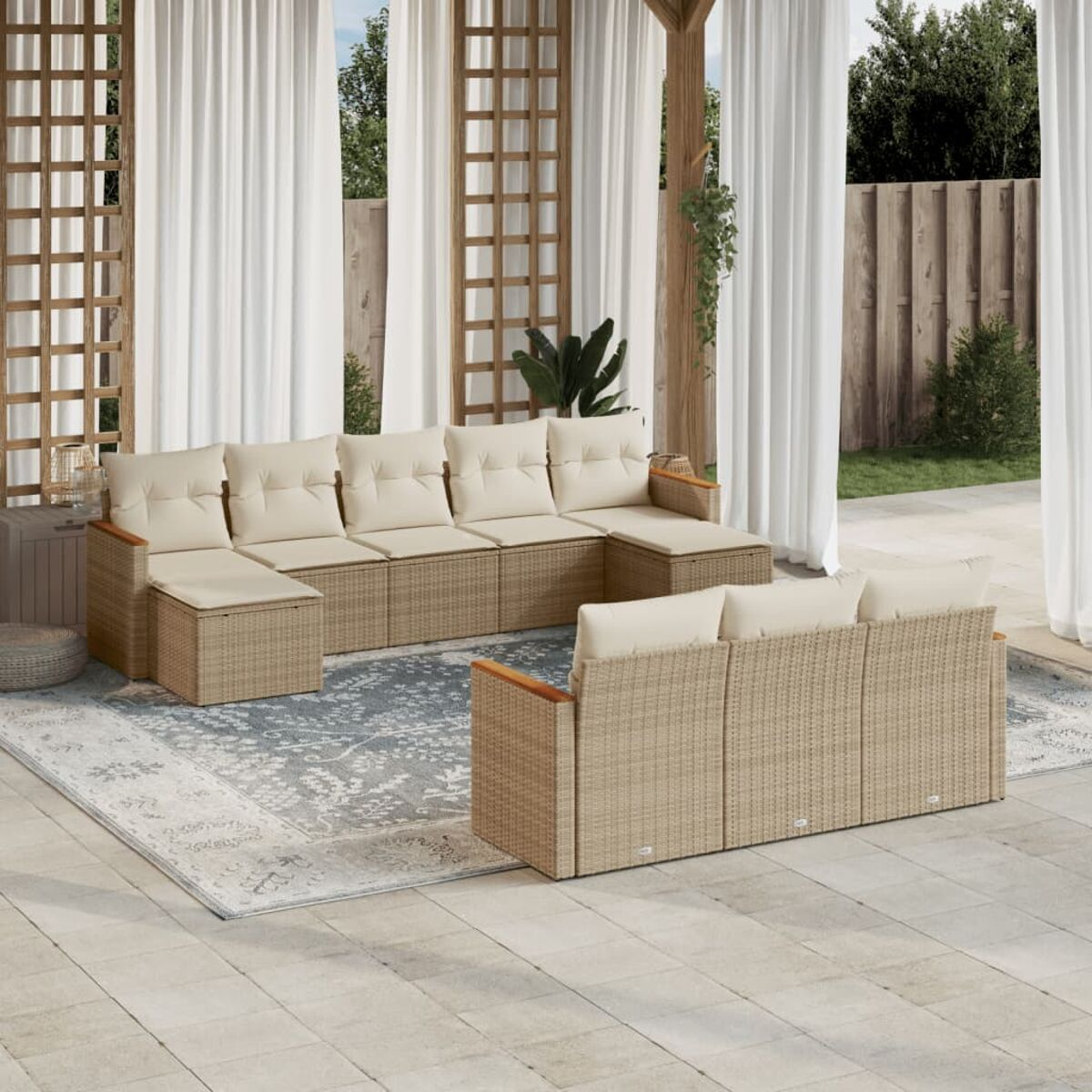 Beiges Outdoor-Ecksofa aus Korbgeflecht auf einer Terrasse mit weißen Vorhängen.