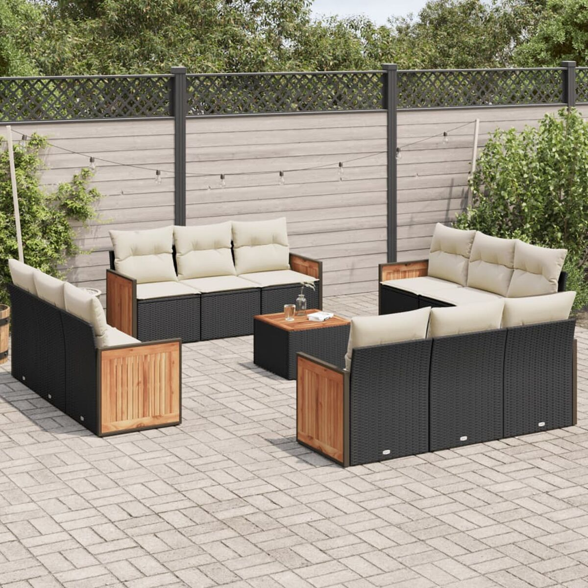 Outdoor-Terrassenset: schwarze Korbmöbel, Holzakzente, beige Kissen, auf Ziegelpflaster, Outdoor-Einstellung.