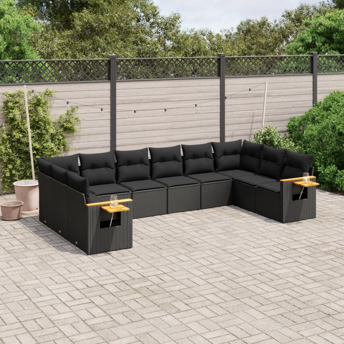 Schwarzes Korbsessel-Ecksofa mit schwarzen Kissen auf einer gepflasterten Terrasse. Ein Holztisch ist vorhanden.
