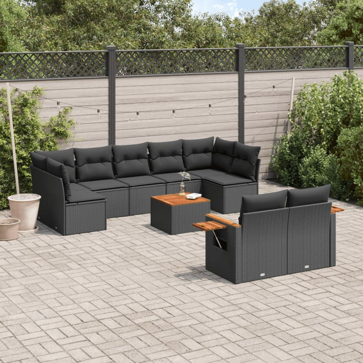 Outdoor-Terrasseneinrichtung mit schwarzem Korbmöbel, Tisch und grauen Kissen.