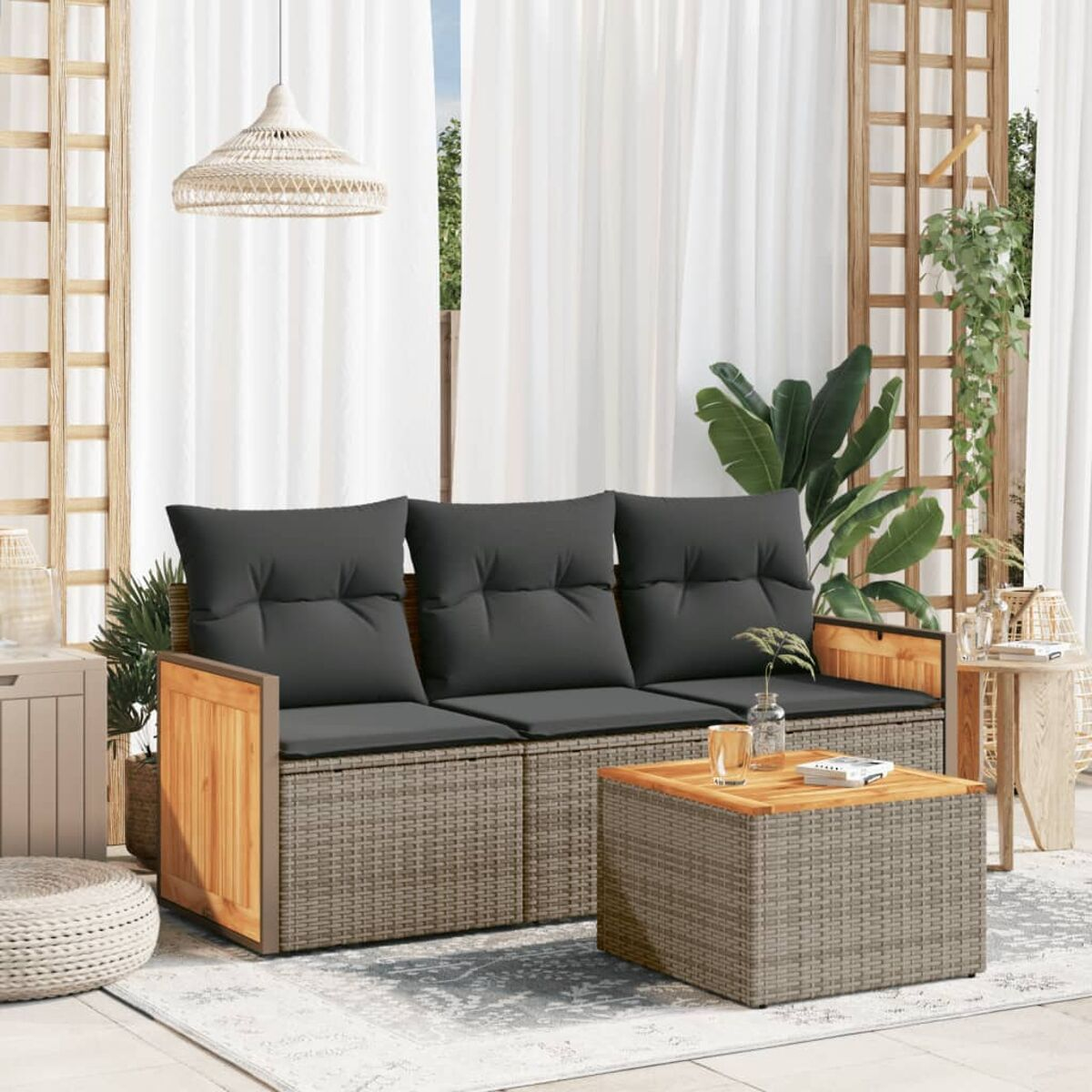 Ein graues Korbmöbelsofa mit schwarzen Kissen und Holzarmlehnen, einem Holztisch und einem Teppich.