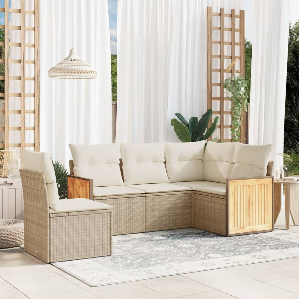 Beiges Outdoor-Wicker-Sofa mit cremefarbenen Kissen. Weiße Vorhänge und ein Holzgitter im Hintergrund.
