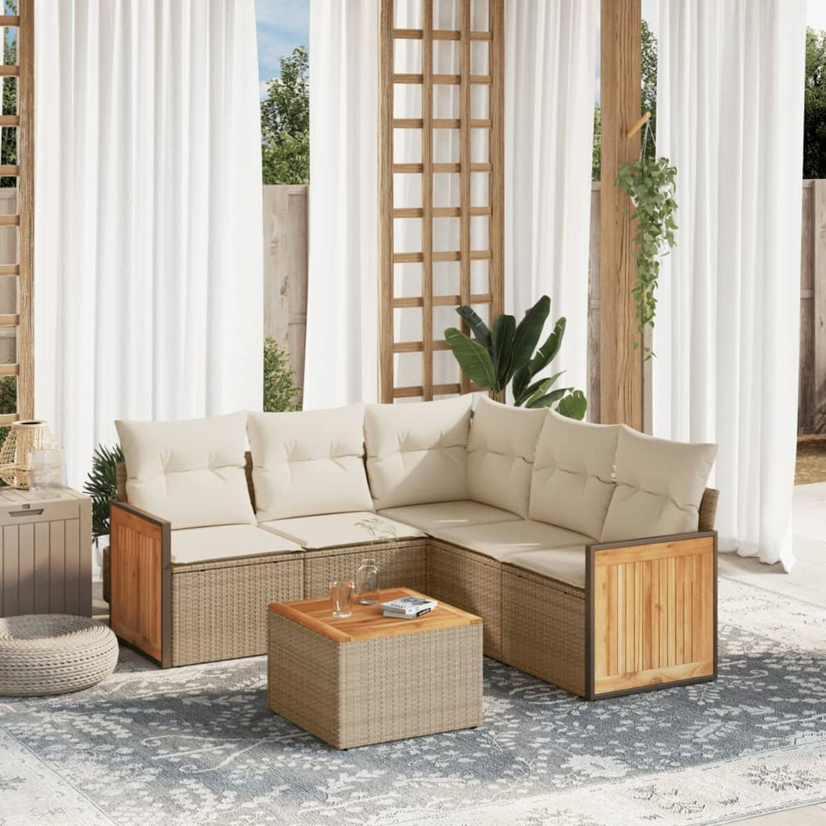 Beiges Outdoor-Ecksofa und -Tisch auf Terrasse mit weißen Vorhängen und Grün.
