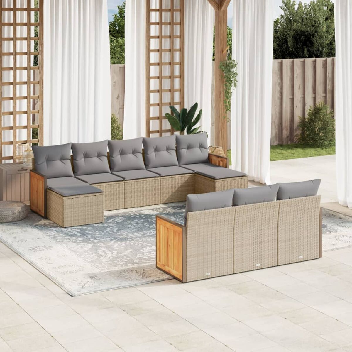 Geflochtenes Outdoor-Ecksofa mit grauen Kissen. Ein Teppich, weiße Vorhänge und ein Holzgitter im Hintergrund.