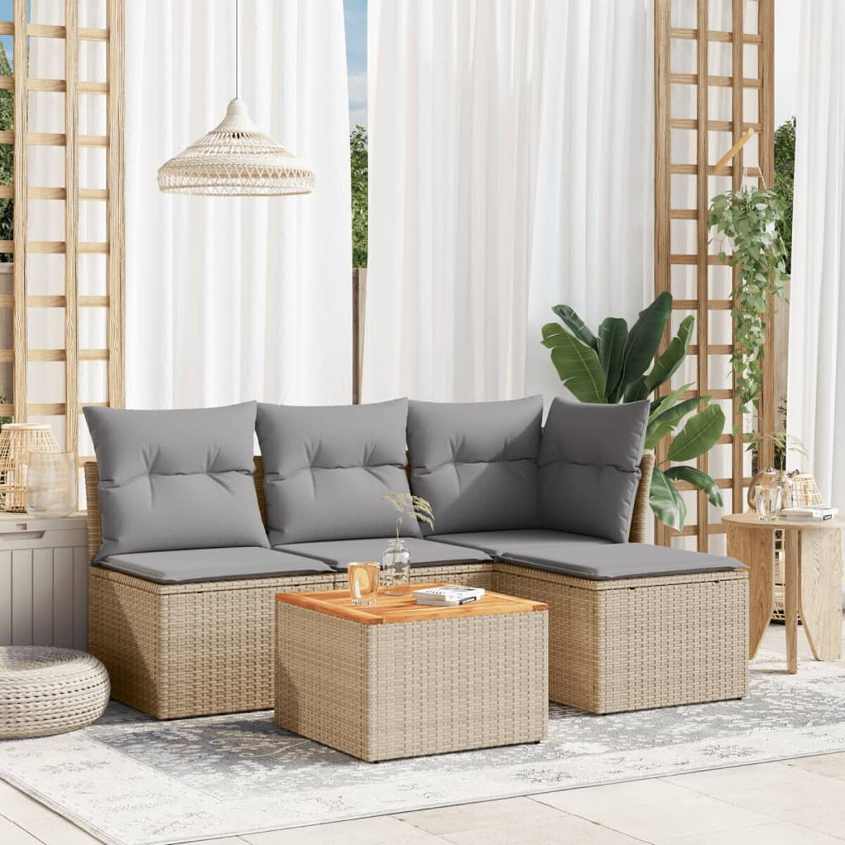 Outdoor-Sitzbereich mit beigem Rattan-Sofa, grauen Kissen, Couchtisch und weißen Vorhängen.