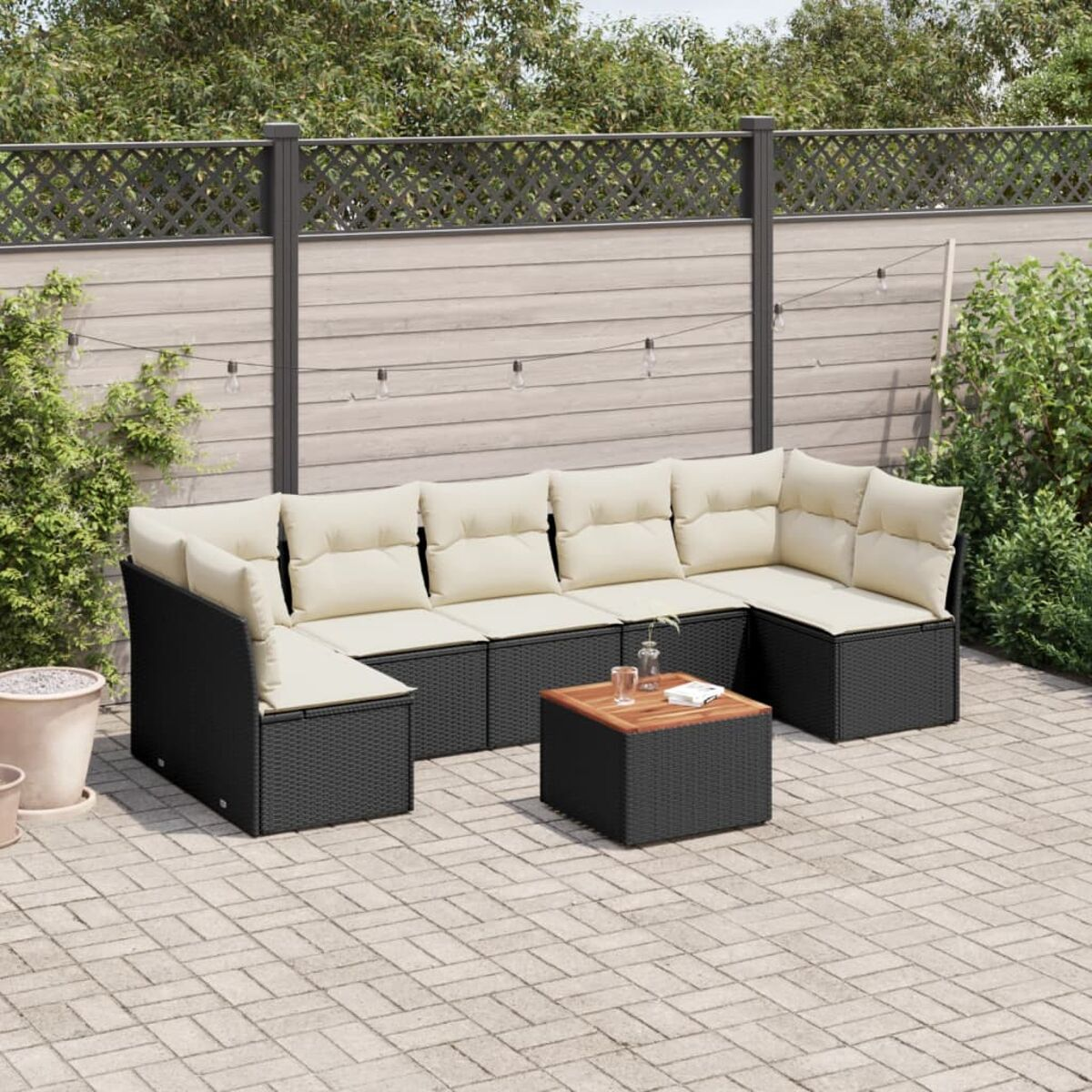 Schwarzes Korbmöbel mit cremefarbenen Kissen, Holzakzenten, Holztisch und Terrasse.